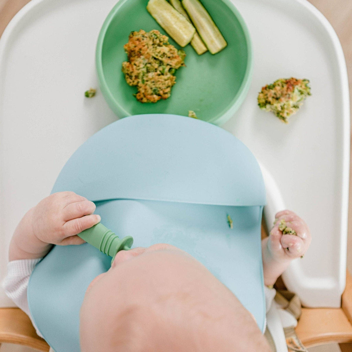 Baby in a high chair using the Starting Solids Australia Selfie Spoon + Fork with a suction plate