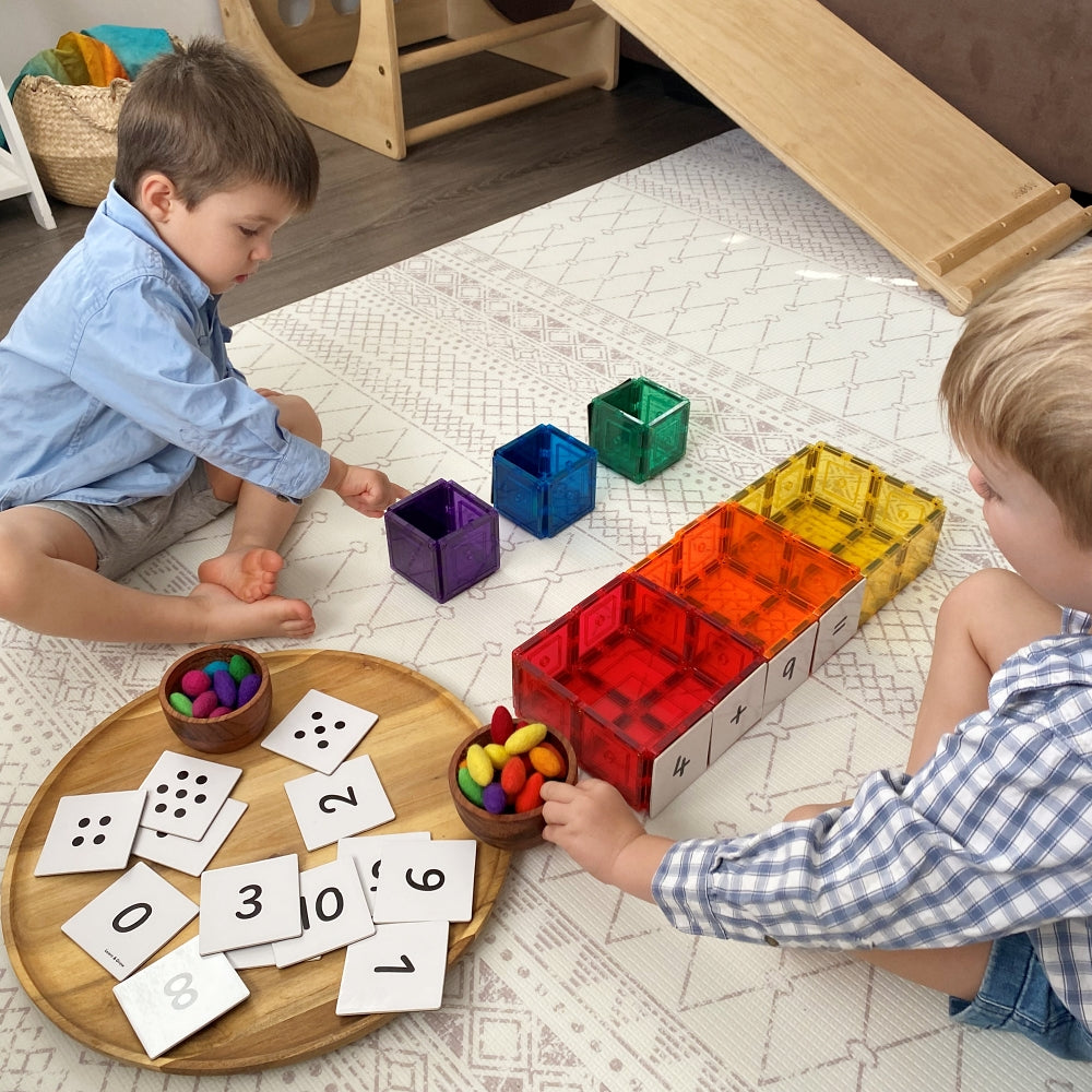 Two children playing with wooden mandalas and Numbers Pack toppers