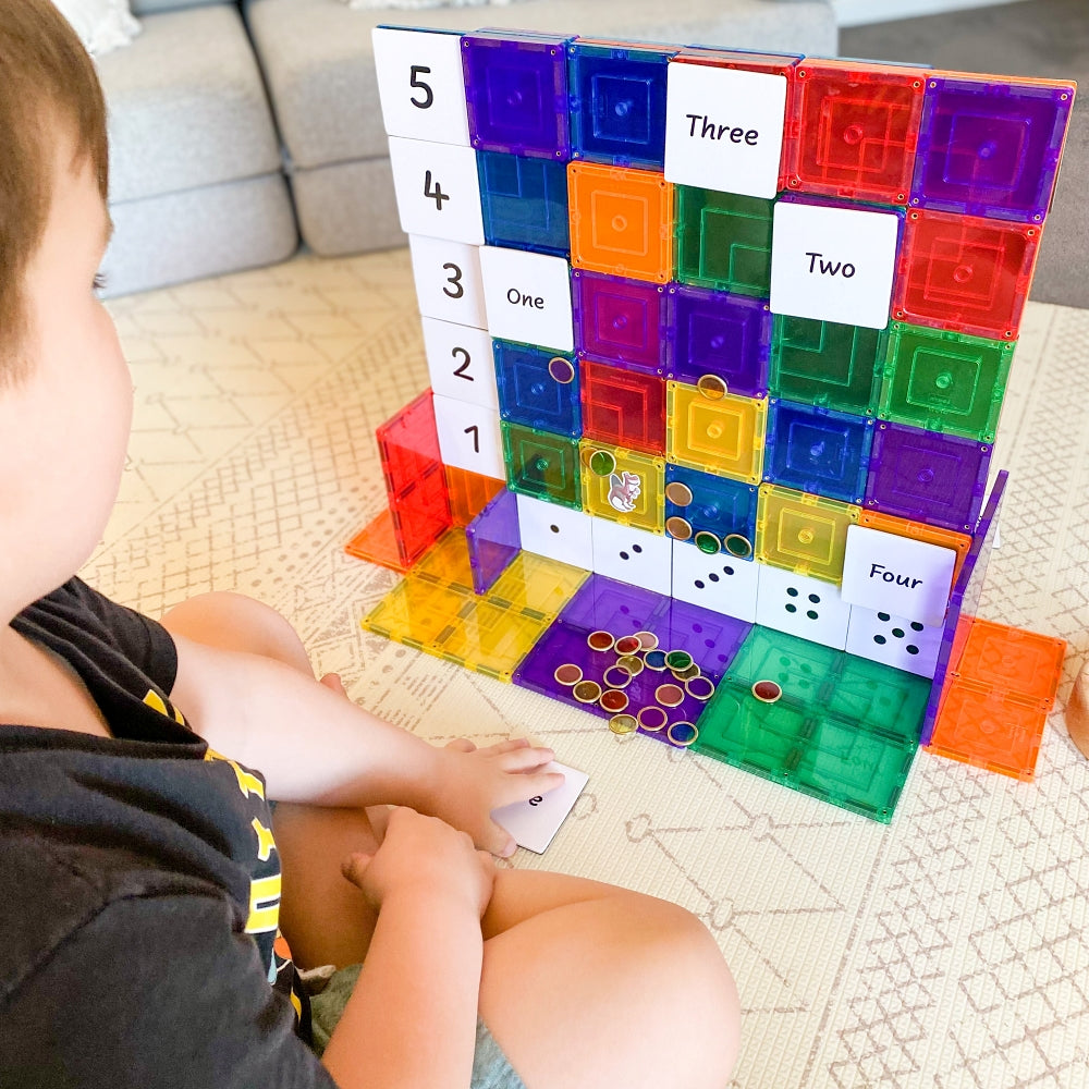 Child playing with Numbers Pack toppers on rainbow magnetic tiles