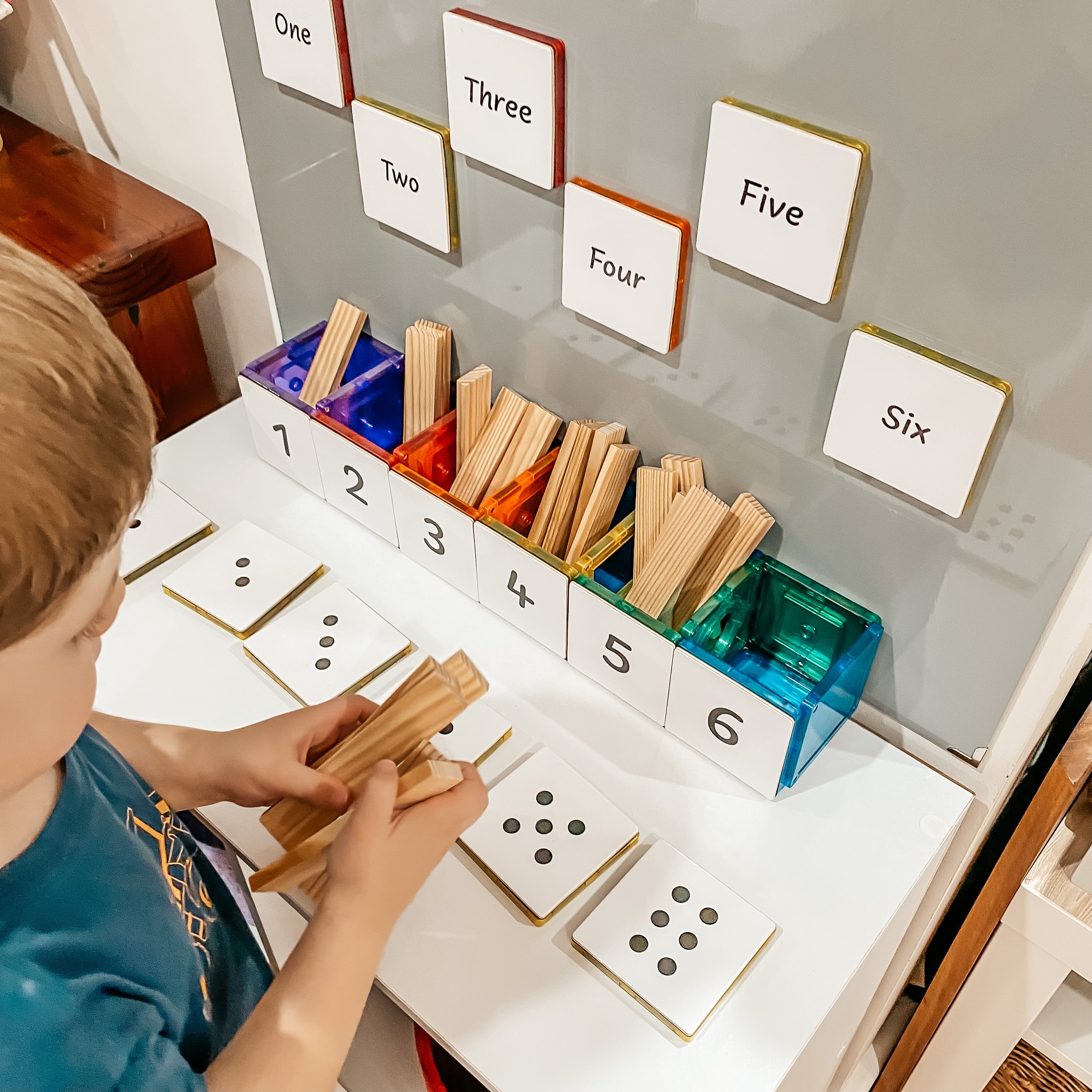Child counting with Numbers Pack toppers and craft sticks