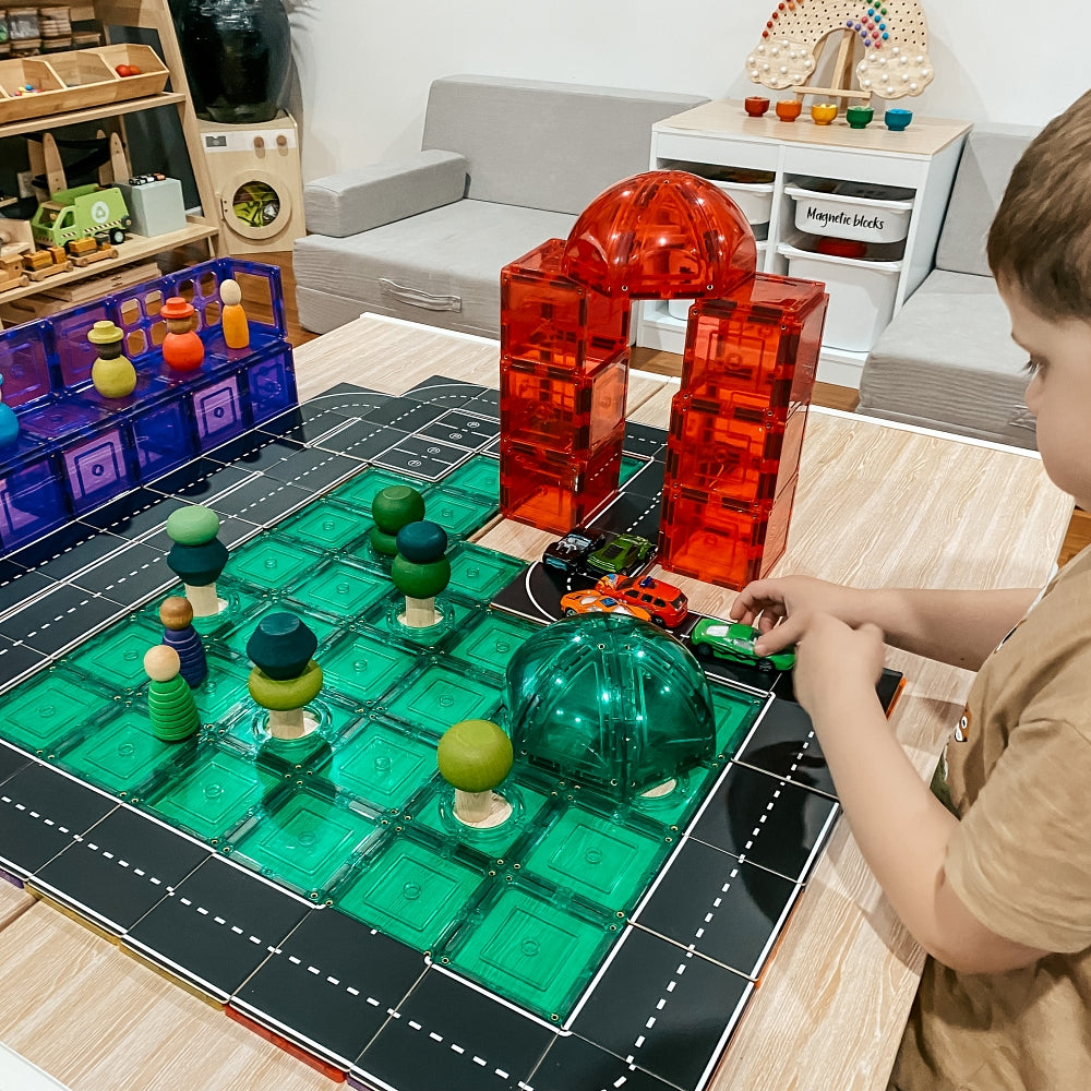 Child building roads with the Road Pack tile toppers on a table
