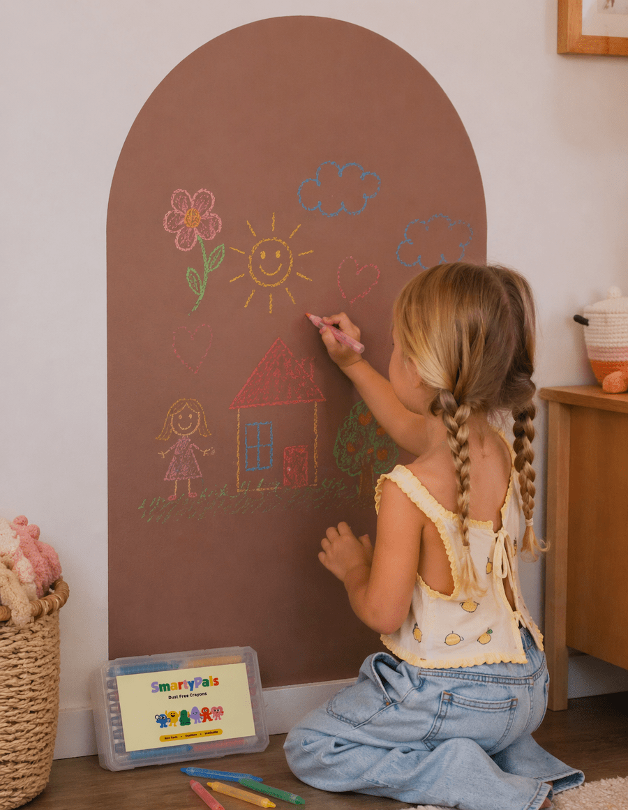 Child drawing on a play wall with Smartypals crayons