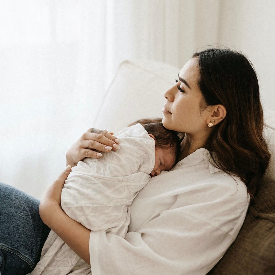 Mother and baby resting, baby wrapped in the Te Patiki Pepi Wrap in Mocha