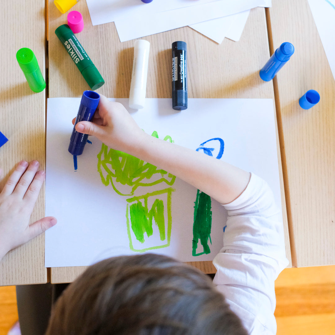 Child using Silkies paint sticks to paint mess free
