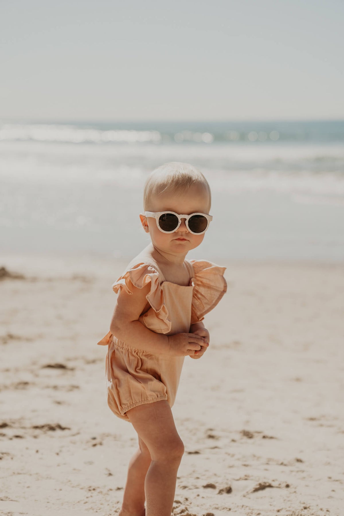 Baby wearing Frankie Ray ECO Baby Sunglasses in Sand Speckle