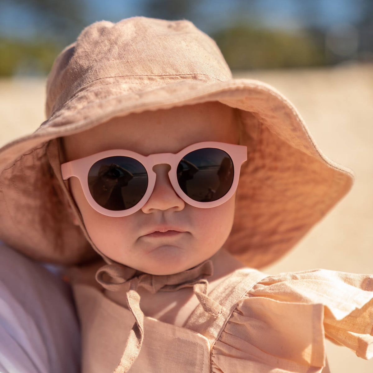 Baby wearing Frankie Ray ECO Baby Sunglasses in Shell Pink