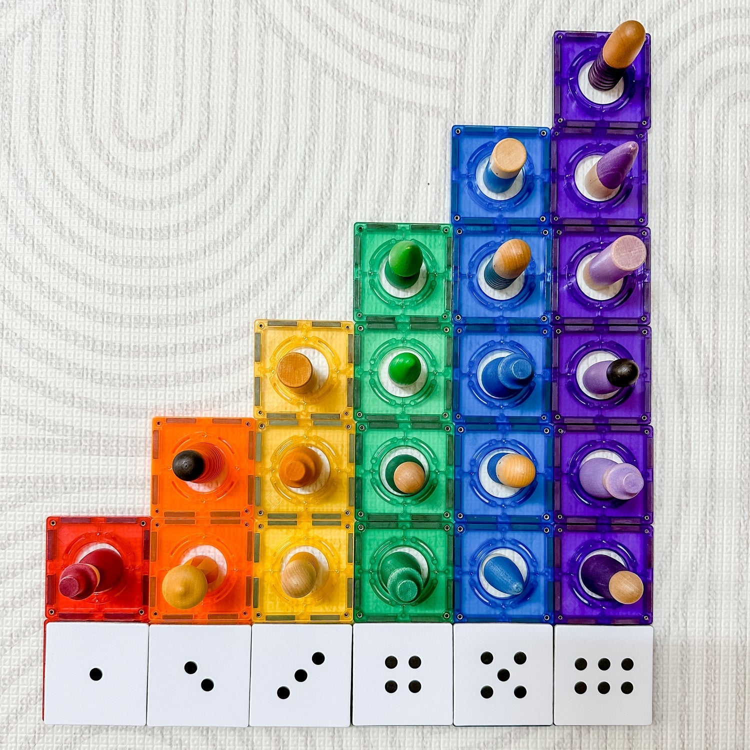 Numbers Pack toppers arranged on rainbow tiles with wooden figures