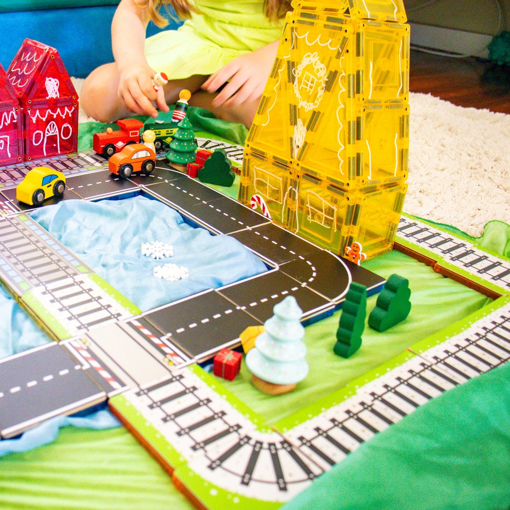 Child playing with Train and Road Pack toppers and magnetic tile houses
