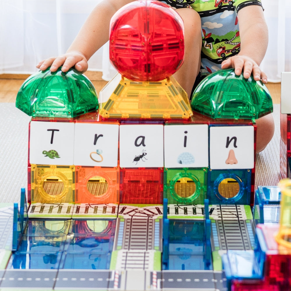 Child building with Train Pack toppers and dome tiles