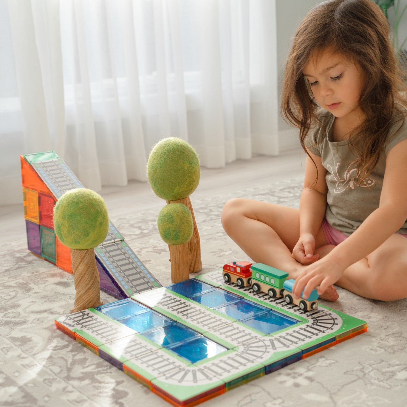 Child playing with the Train Pack magnetic tile track toppers