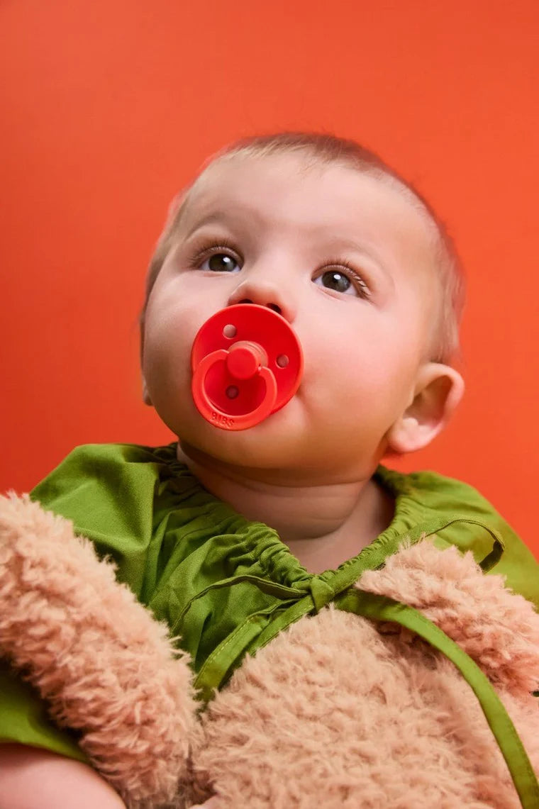 bibs round colour glow pacifiers in baby pink and tango
