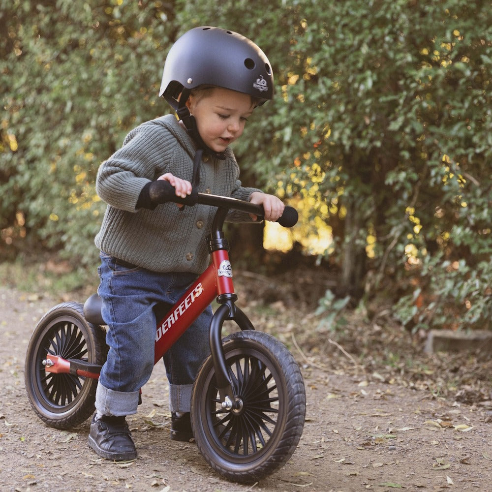 Toddler riding the Kinderfeets Trail Bike in Red