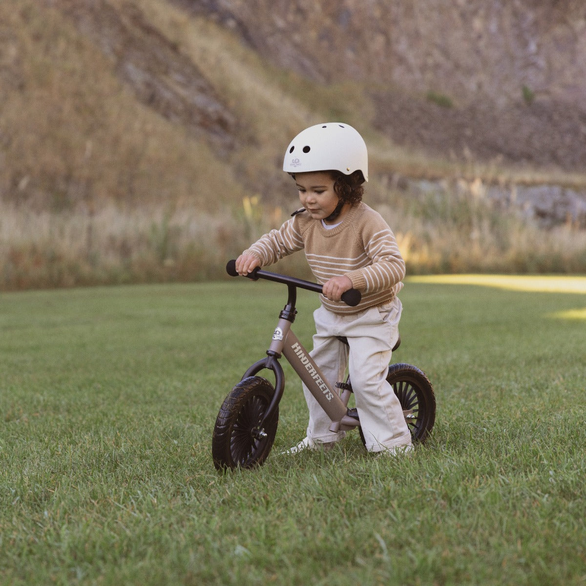 Toddler riding the Kinderfeets Trail Bike in Slate Grey