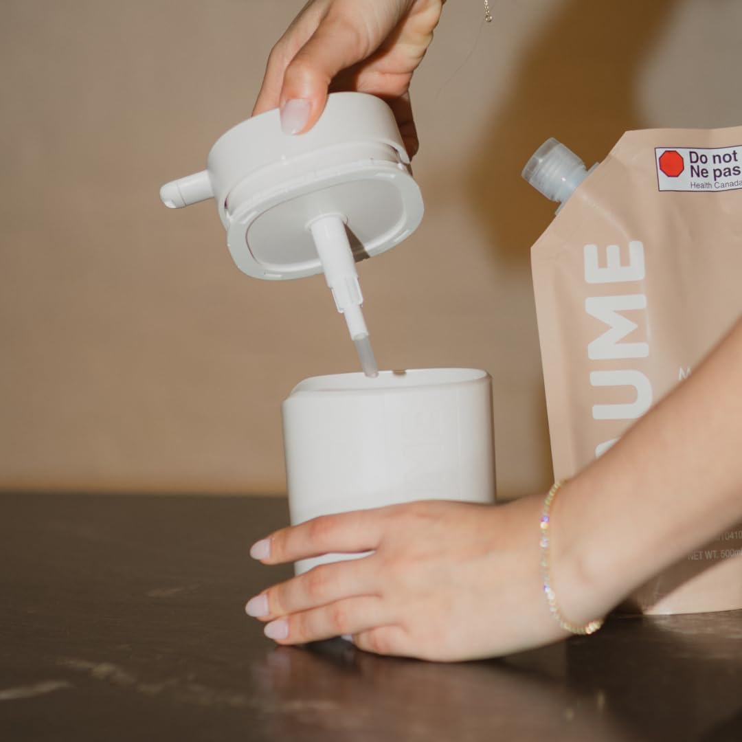 Person pouring liquid from a white container into another white container with a brown package labeled 'UME' in the background.