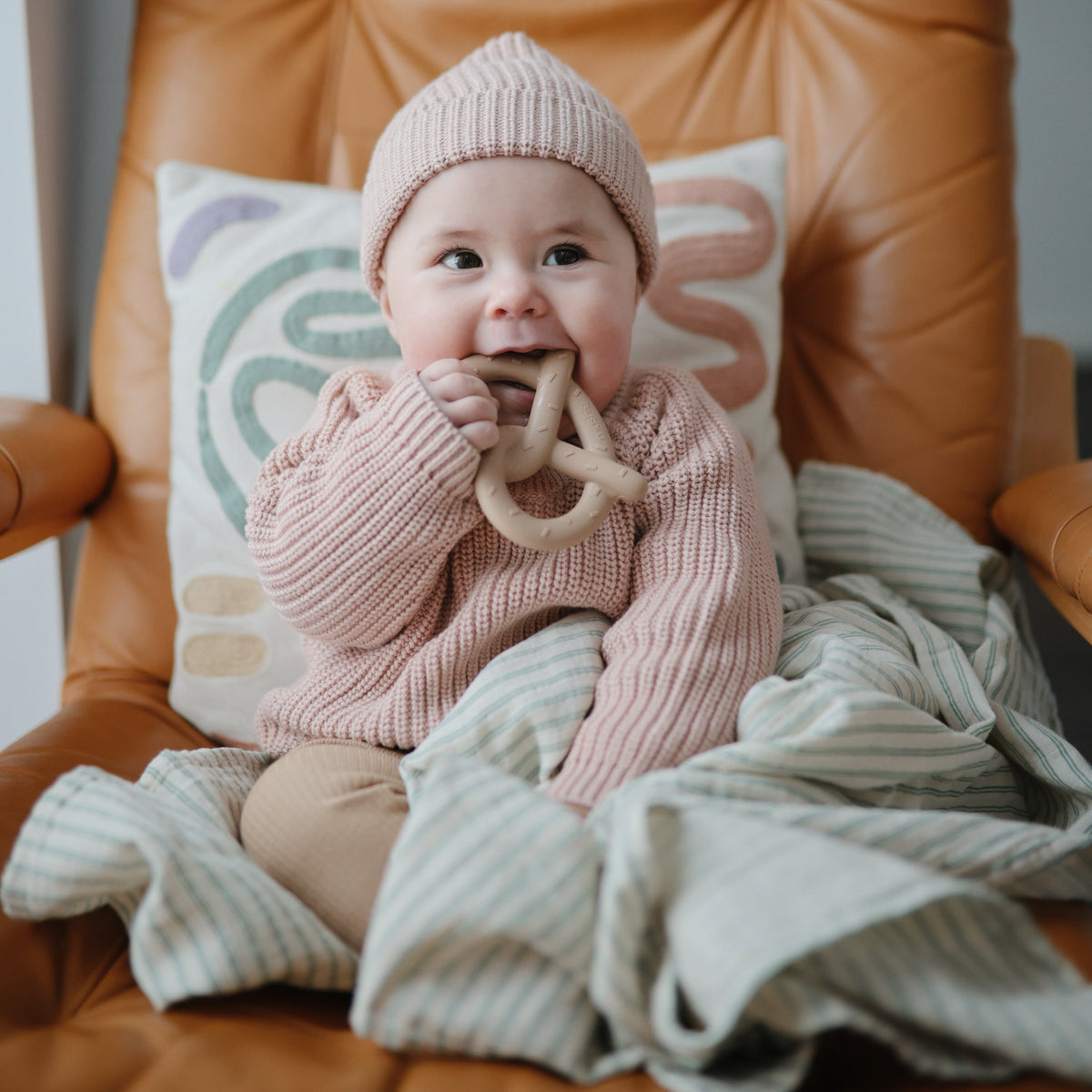 Baby chewing the Mushie Pretzel Teether