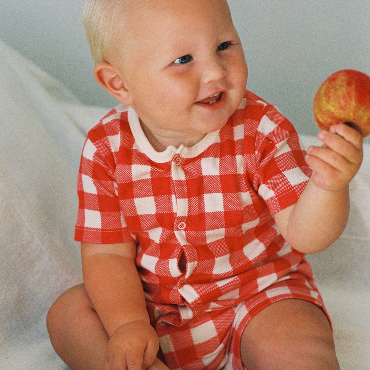 Summer Sleepy Suit in Red Crispin Check worn by baby
