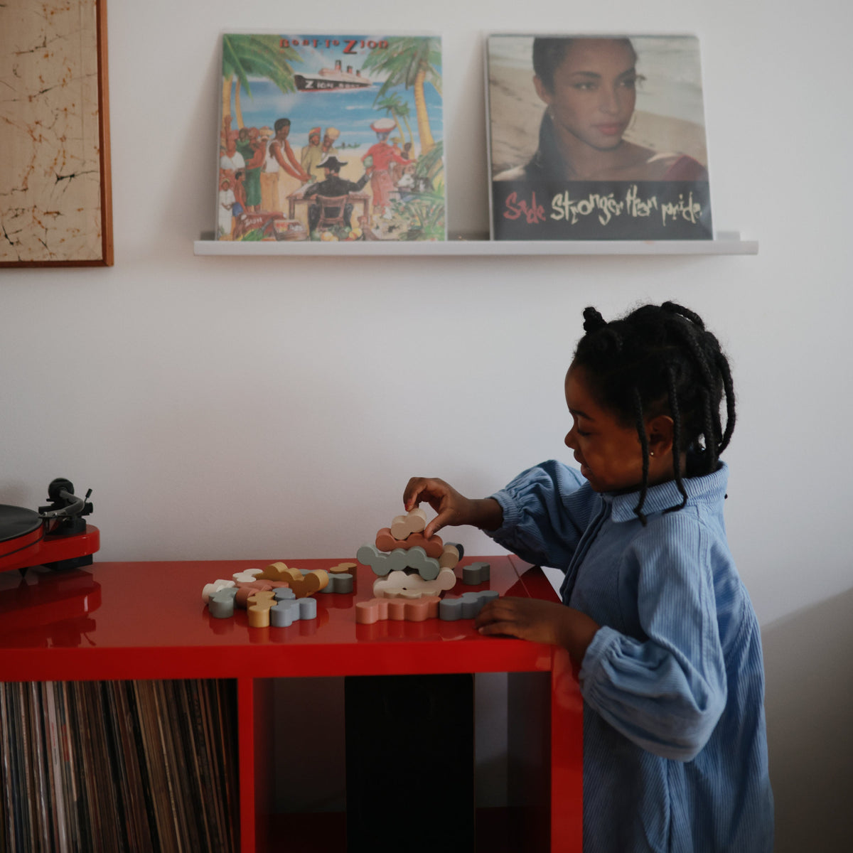 Child building with Mushie Wooden Balance Blocks