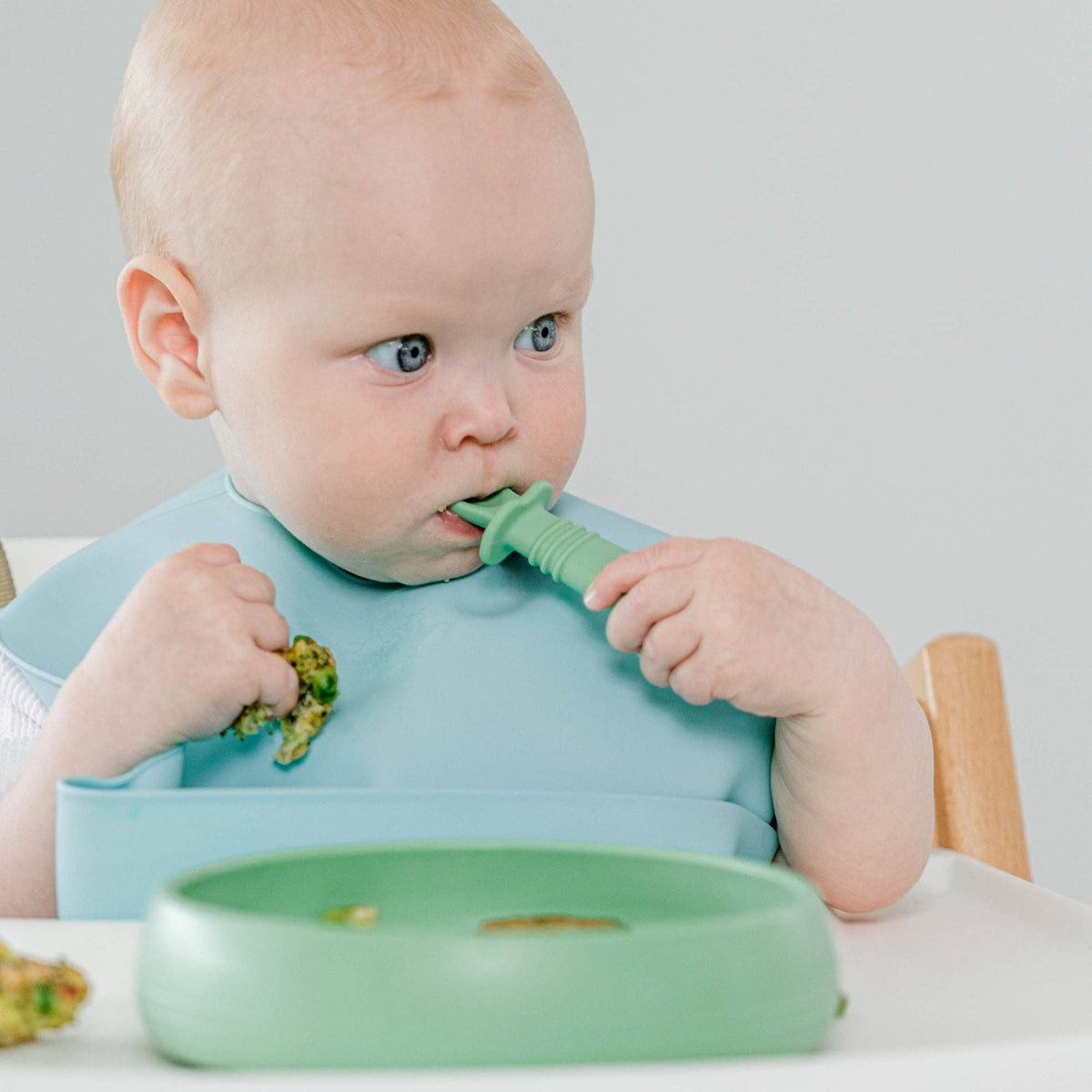 Baby feeding themselves with the Starting Solids Australia Selfie Fork at the high chair