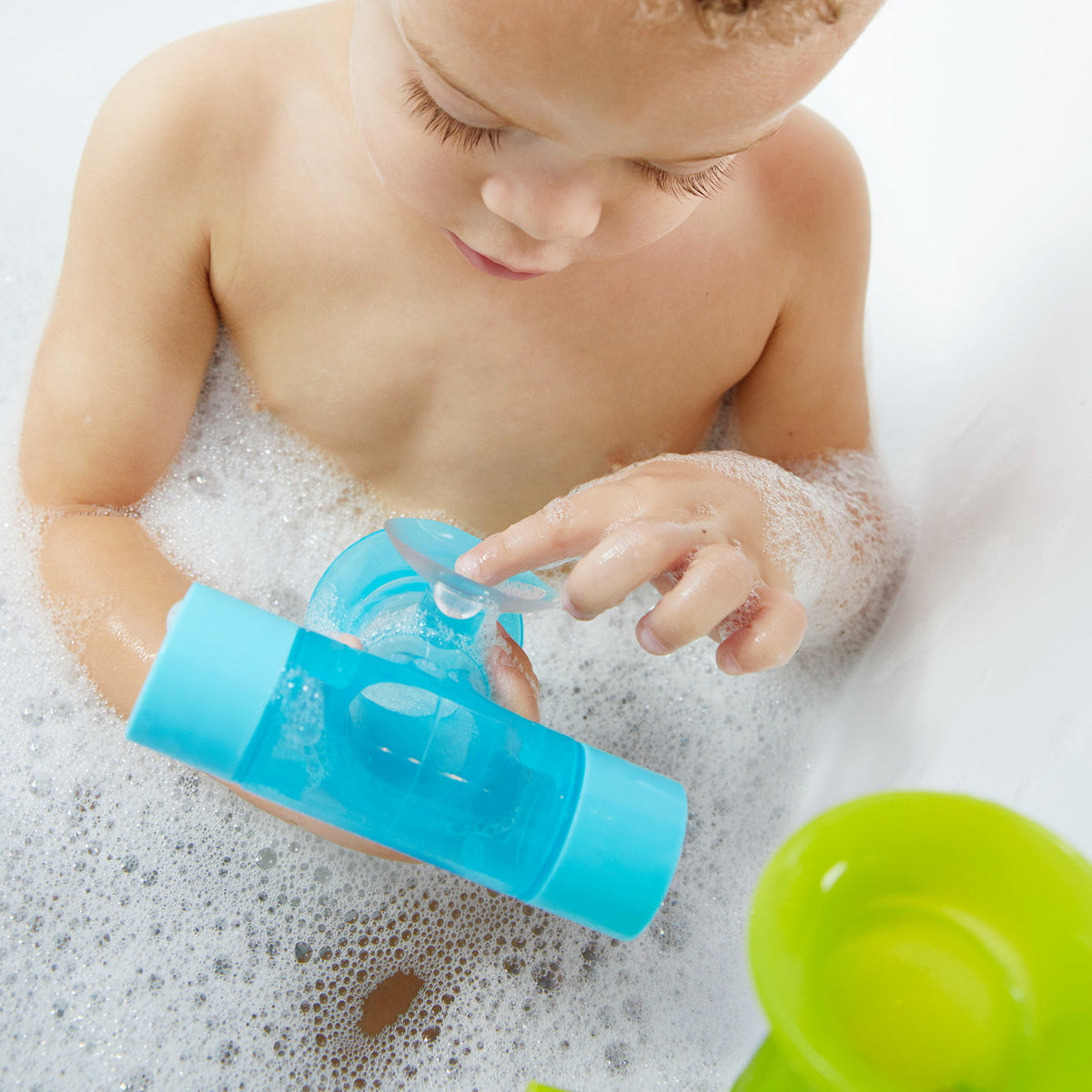 Child pouring water through the Boon Pipes Bright bath toy chain