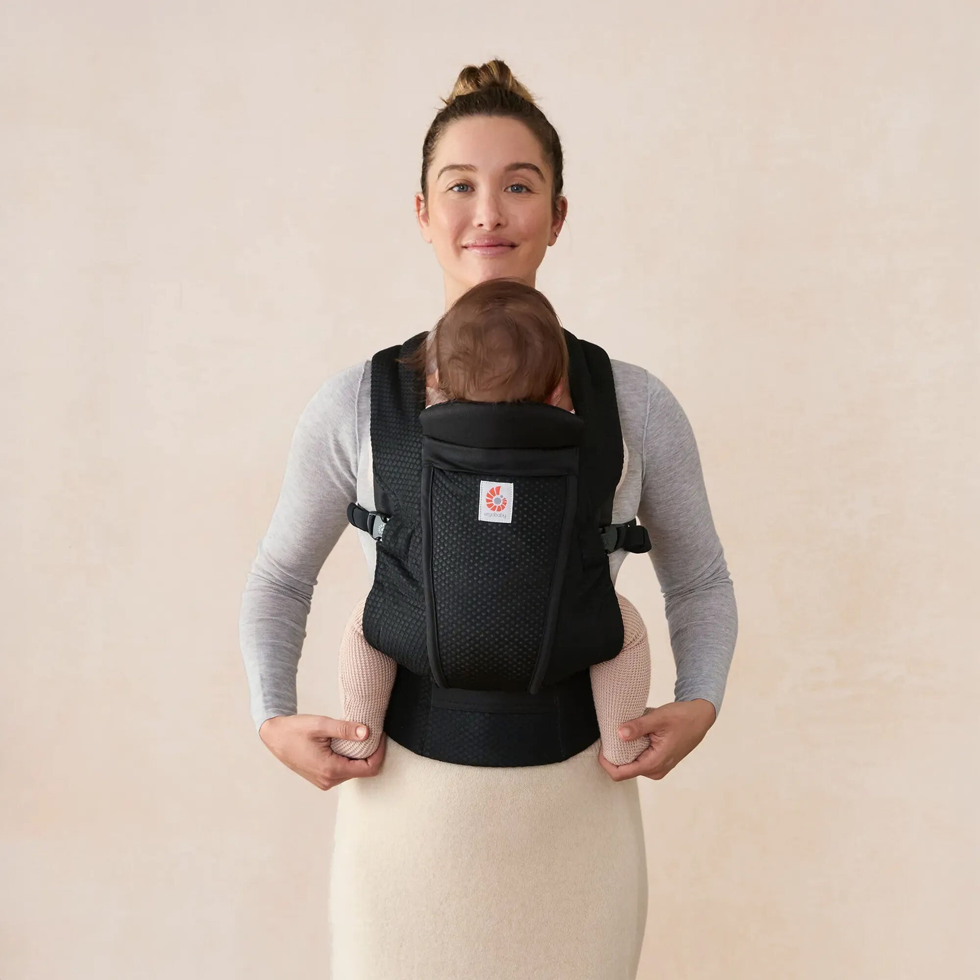 Parent wearing Ergobaby Omni Lite in Onyx Black, front inward carry