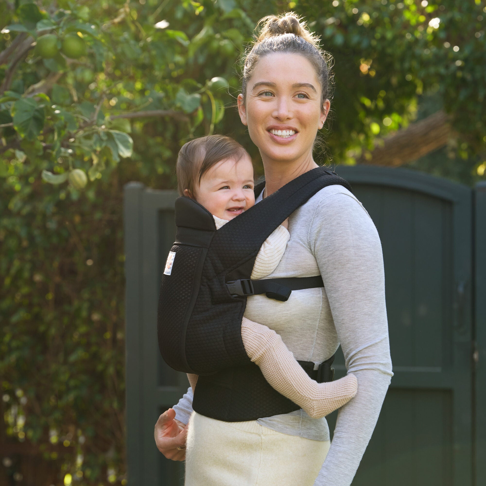 Parent carrying baby outdoors in Ergobaby Omni Lite Onyx Black