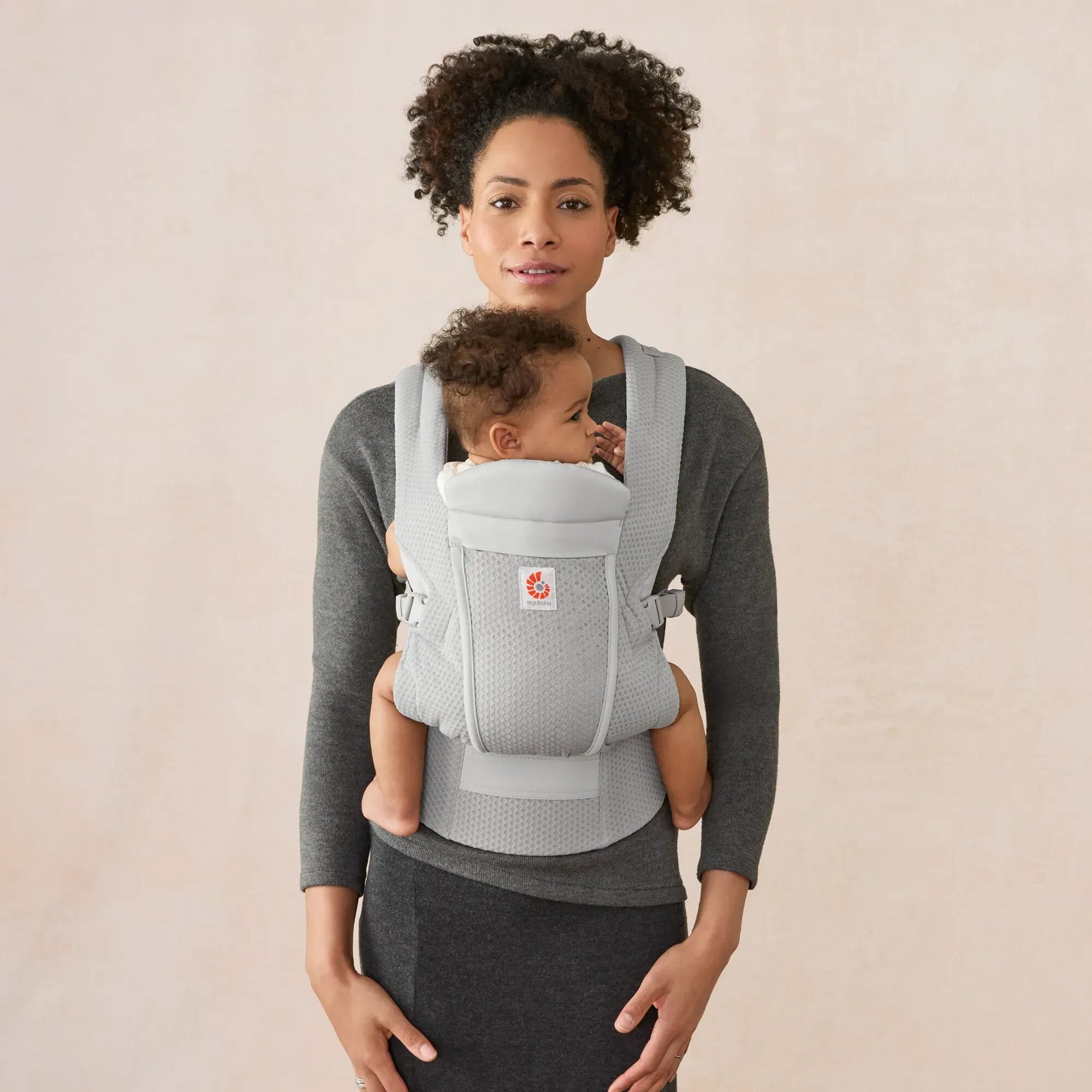 Parent wearing Ergobaby Omni Lite in Pearl Grey, front inward carry