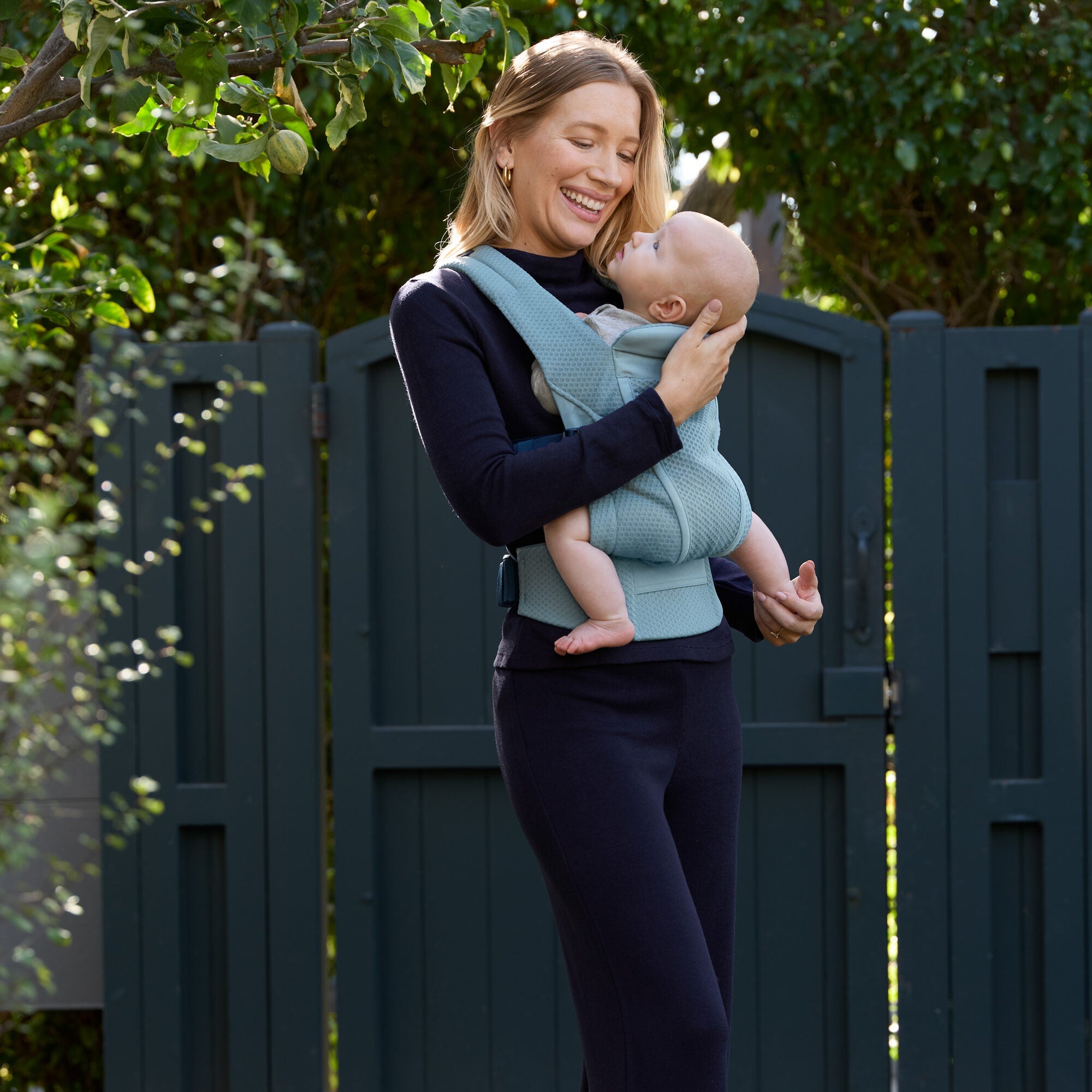 Parent carrying baby outdoors in Ergobaby Omni Lite Slate Blue