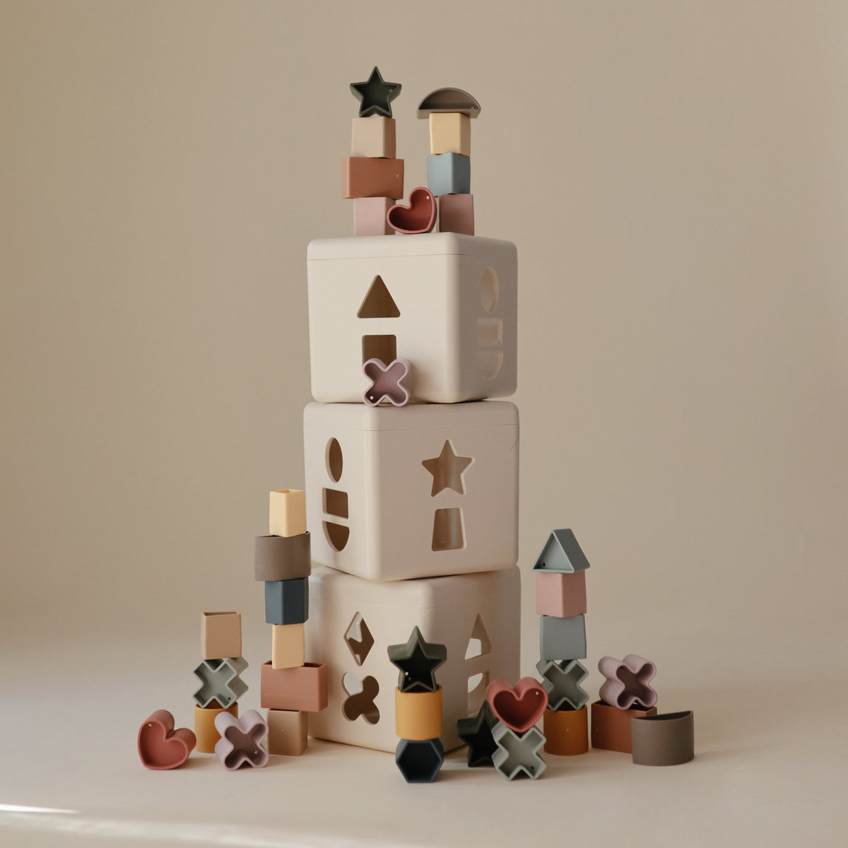 Mushie Shape Sorting Boxes stacked with shapes