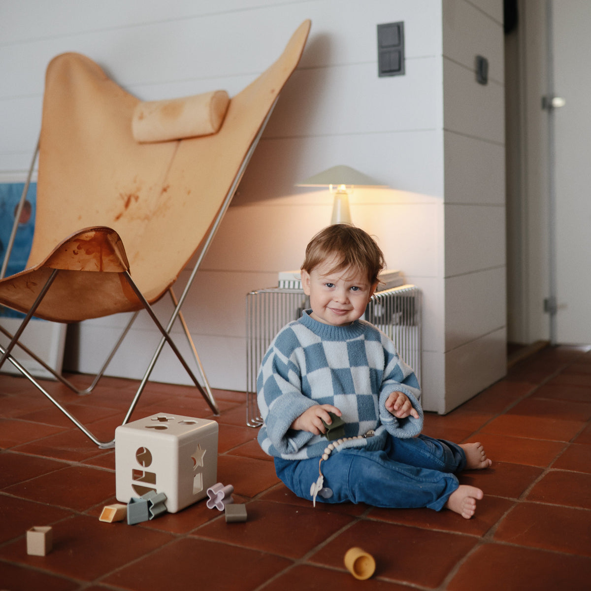Child playing with the Mushie Shape Sorting Box