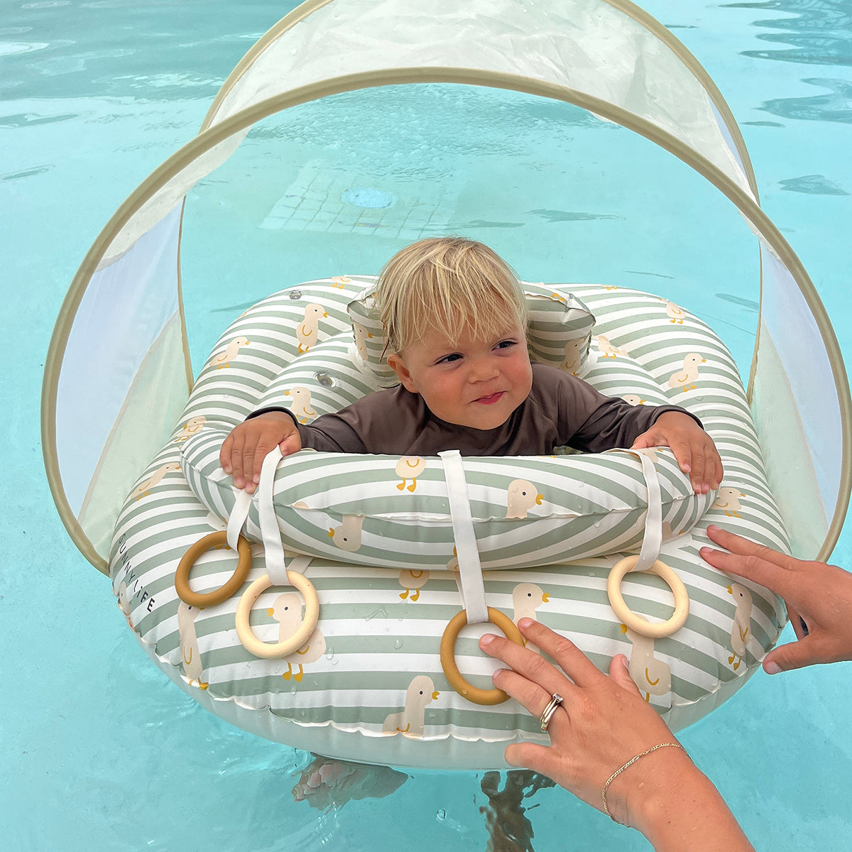 Baby in the Sunnylife Interactive Baby Float in the pool
