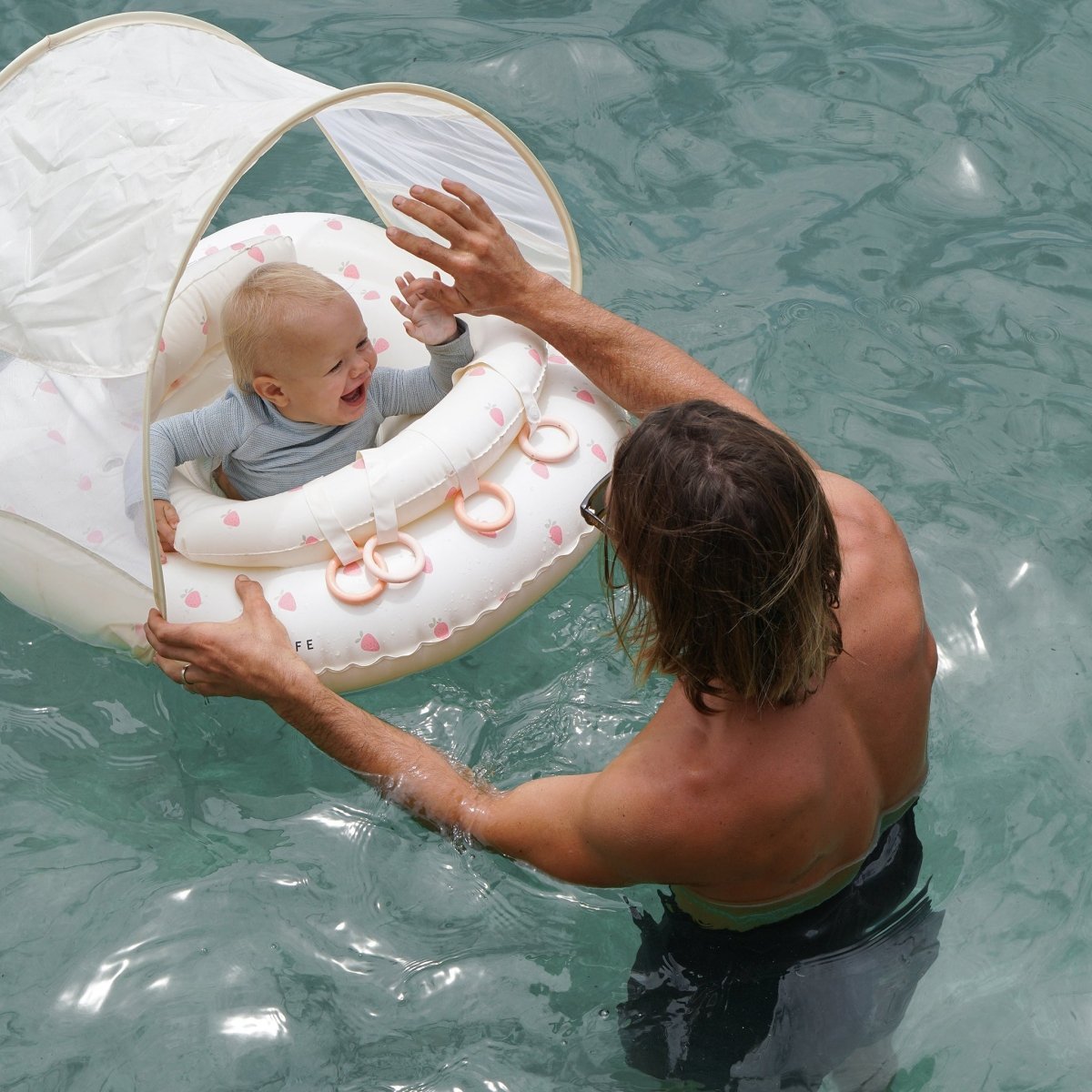 Baby in the Sunnylife Interactive Baby Float Strawberry Sunshine Pink in the pool