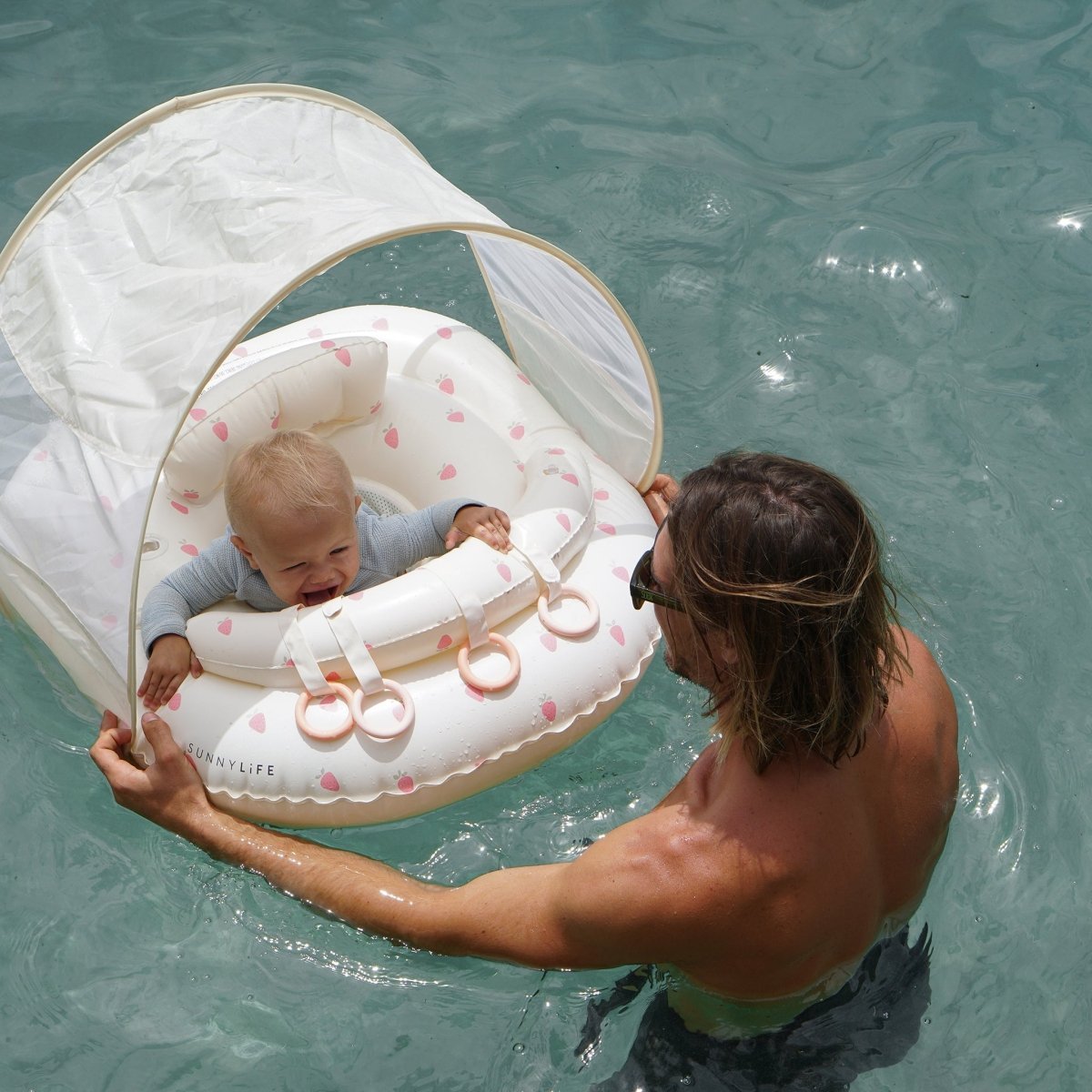 Baby playing in the Sunnylife Interactive Baby Float Strawberry Sunshine Pink