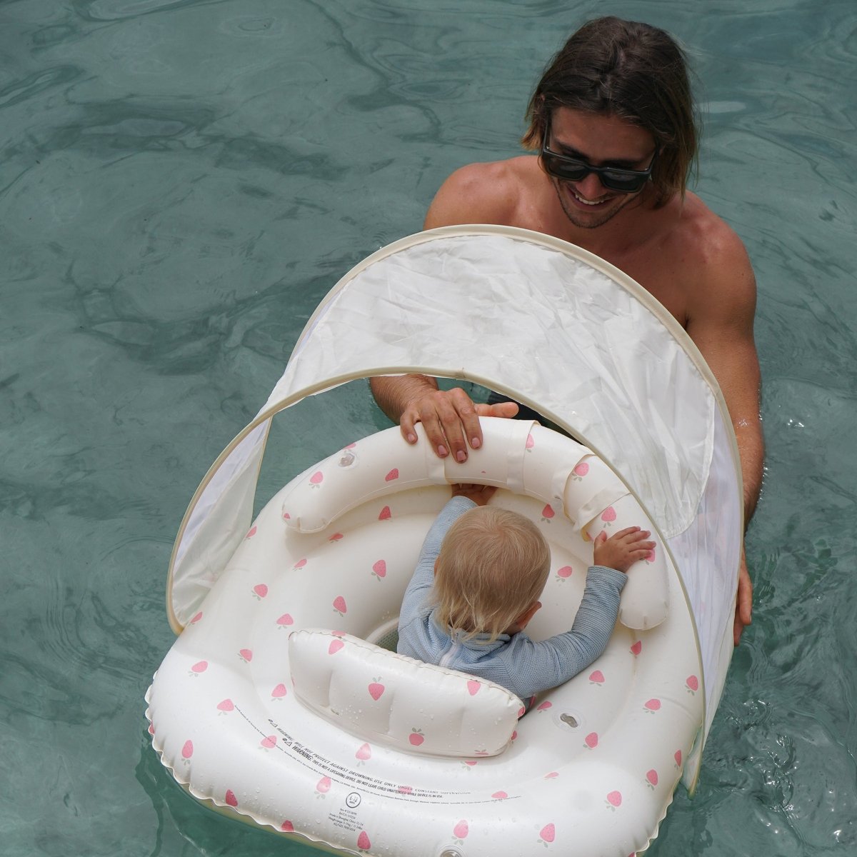 Sunnylife Interactive Baby Float Strawberry Sunshine Pink with canopy up in the pool