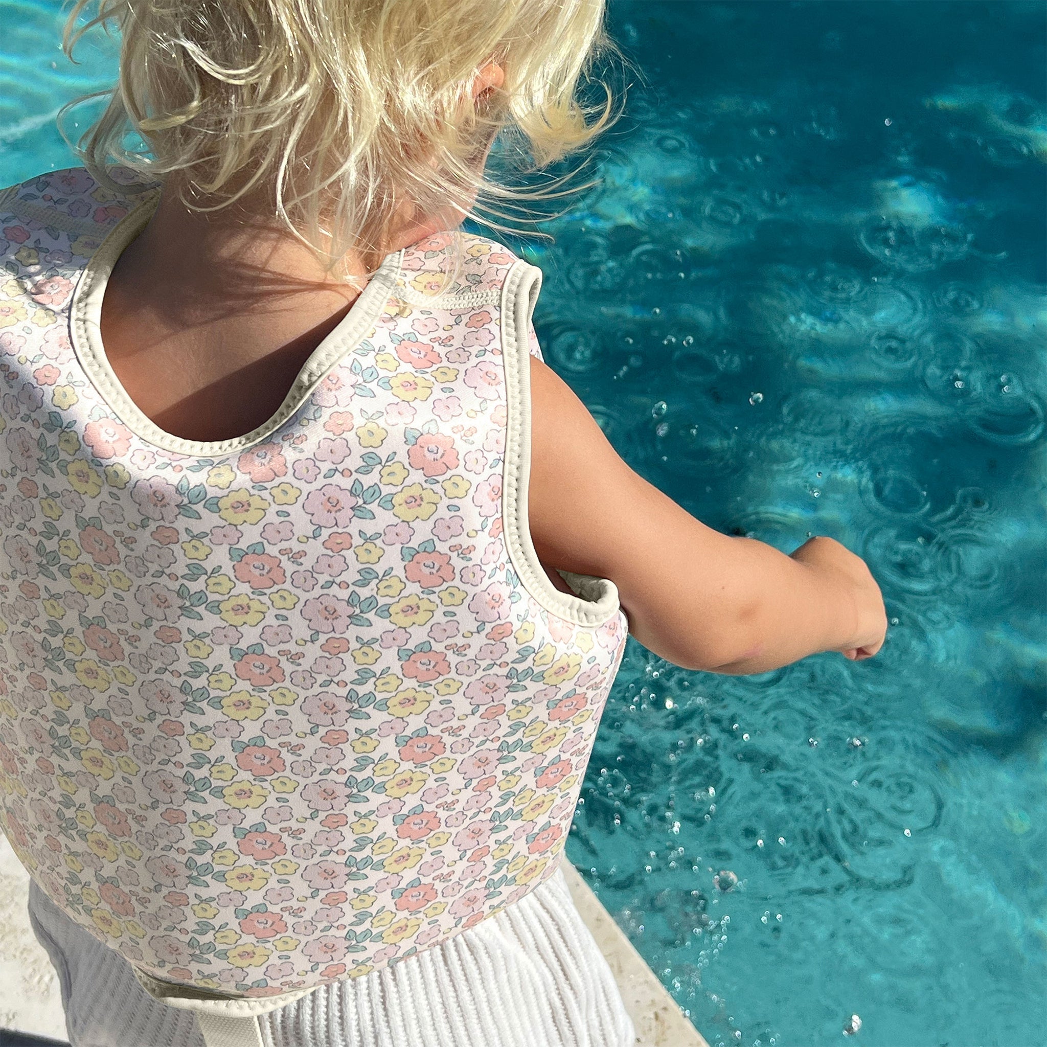 Child wearing the Sunnylife Kids Swim Vest Into the Garden Ditsy Floral
