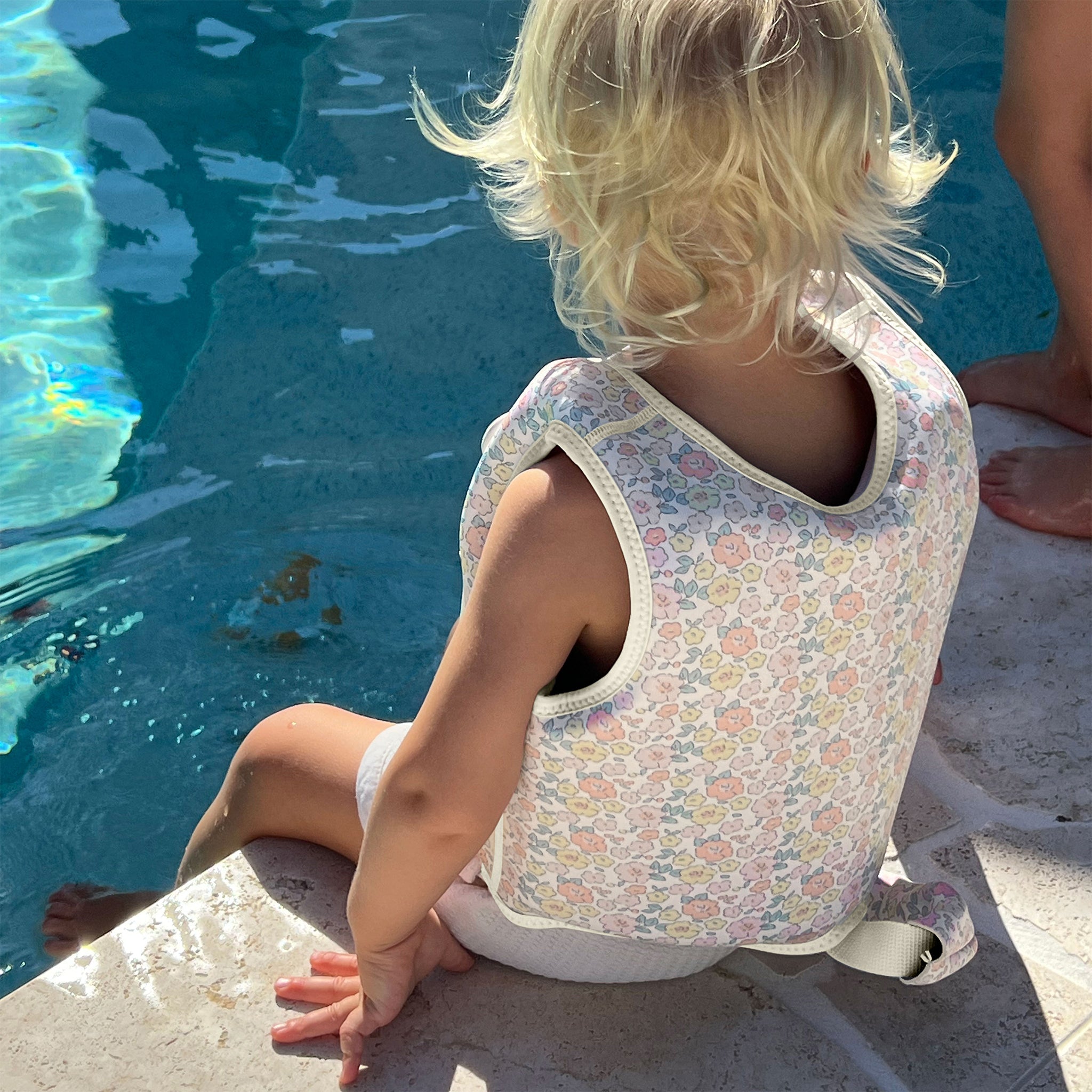 Child swimming in the Sunnylife Kids Swim Vest Into the Garden Ditsy Floral