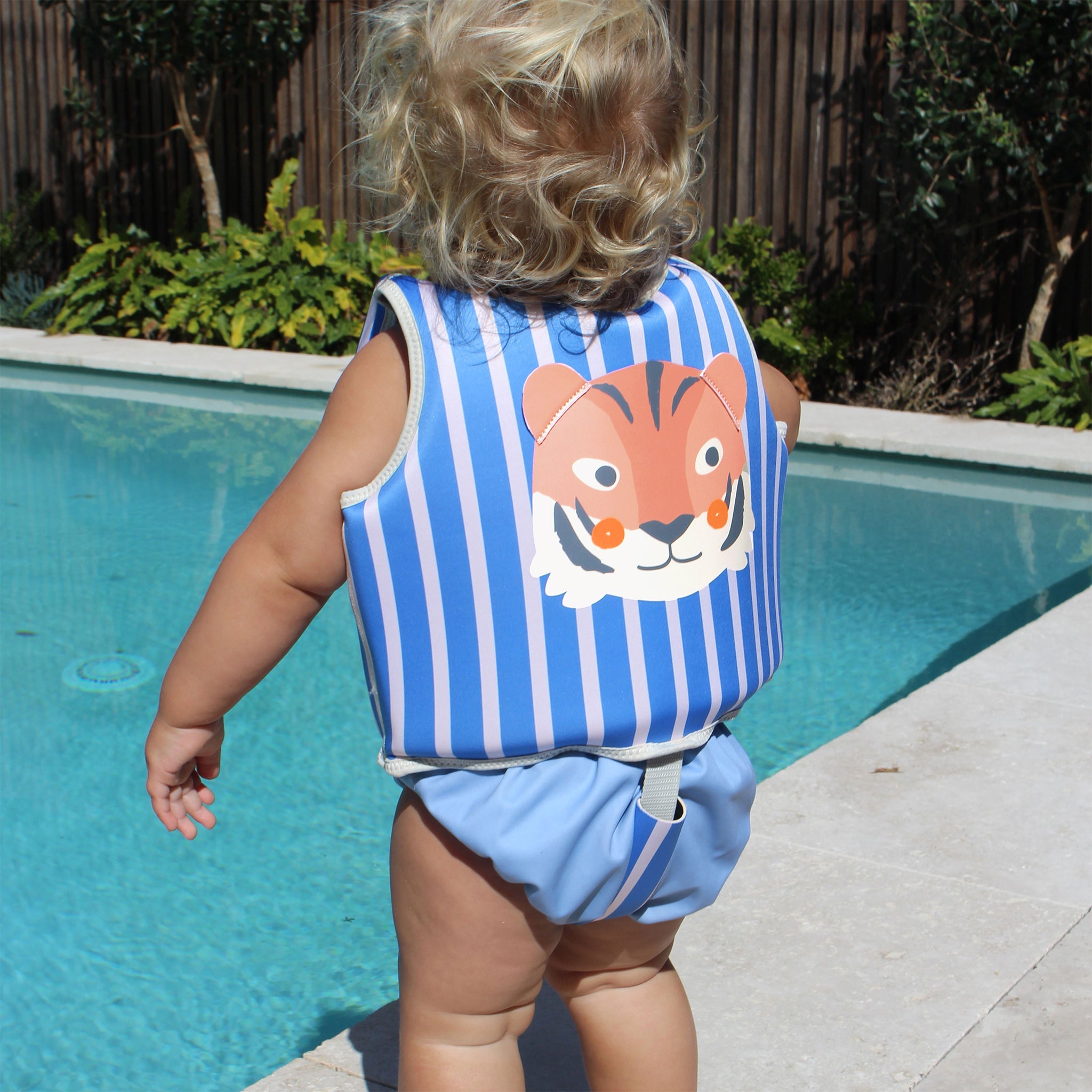 Child wearing the Sunnylife Kids Swim Vest Tino the Tiger Blue