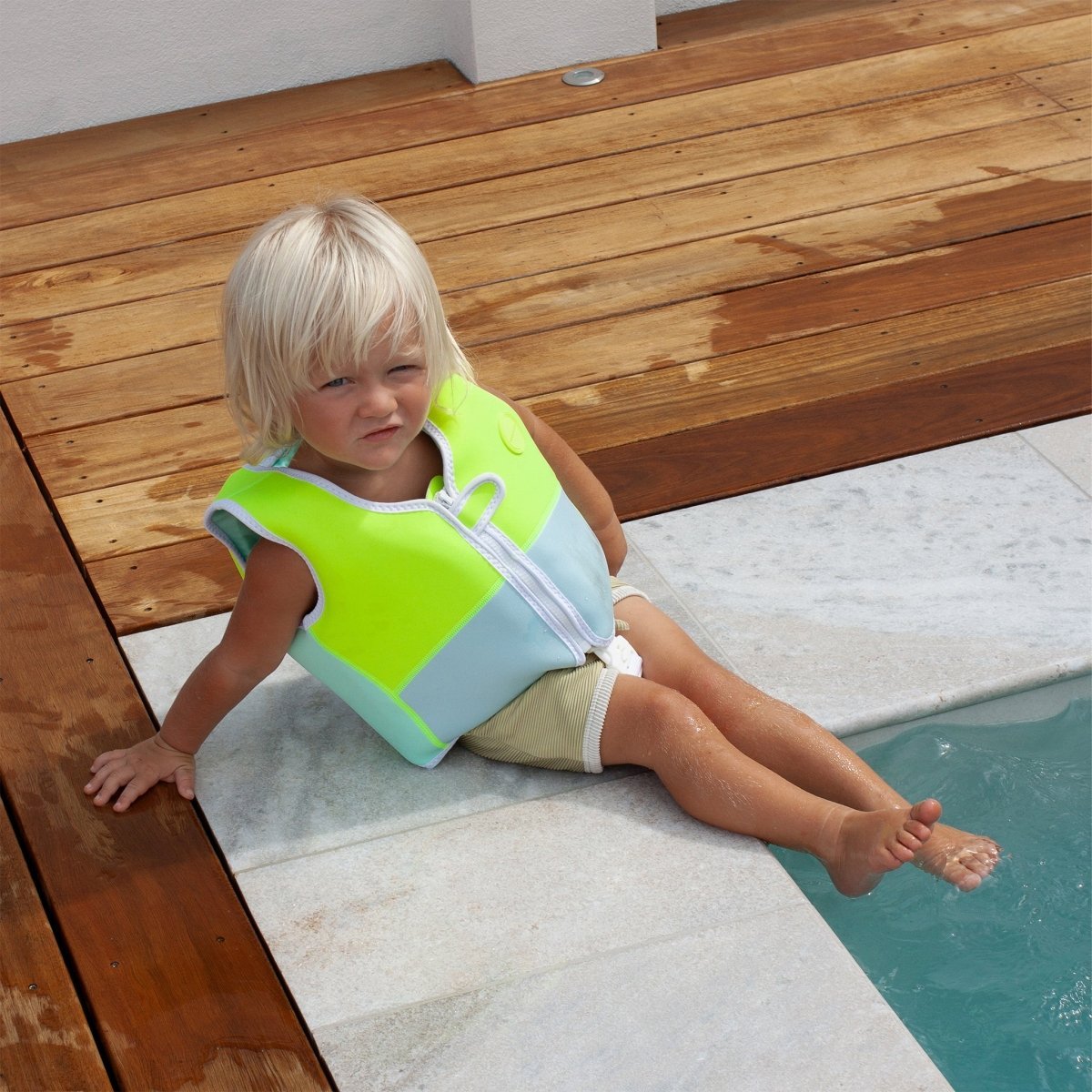 Child wearing the Sunnylife Kids Swim Vest Salty the Shark Aqua Neon
