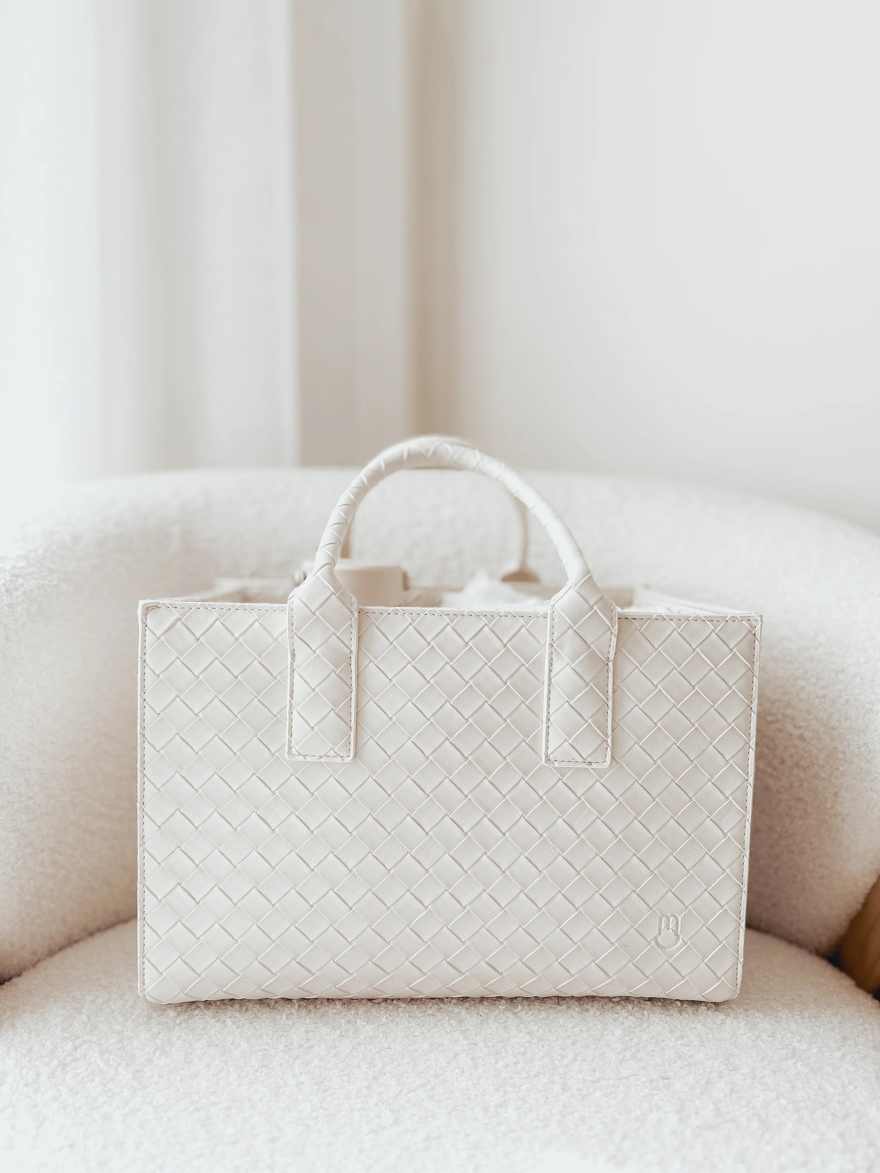 White woven handbag on a light-colored sofa