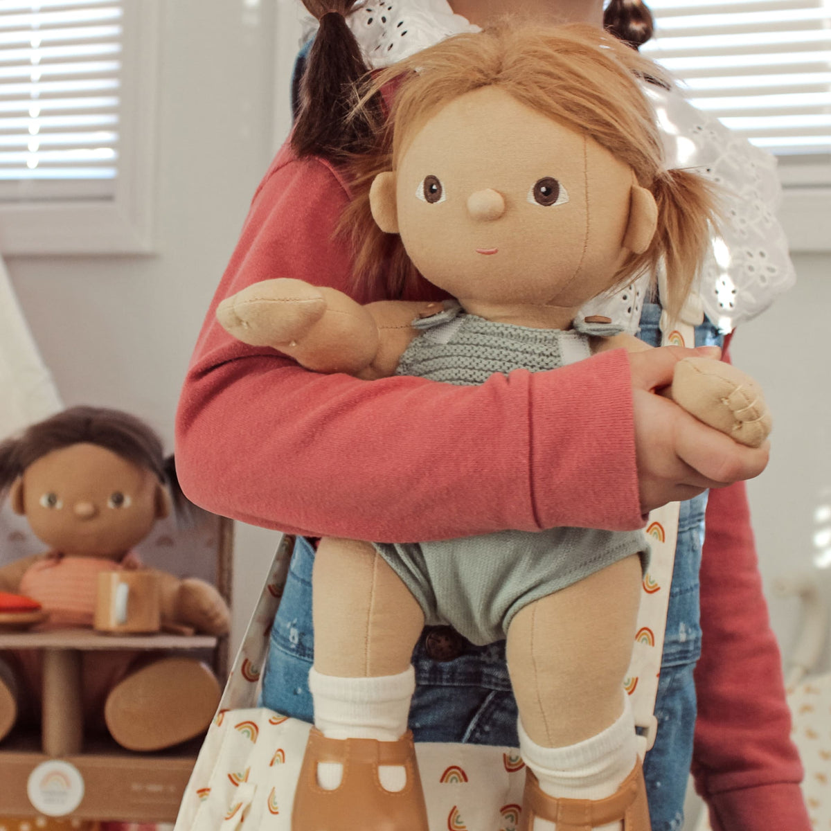 Dinkum Doll Gigi held by a child