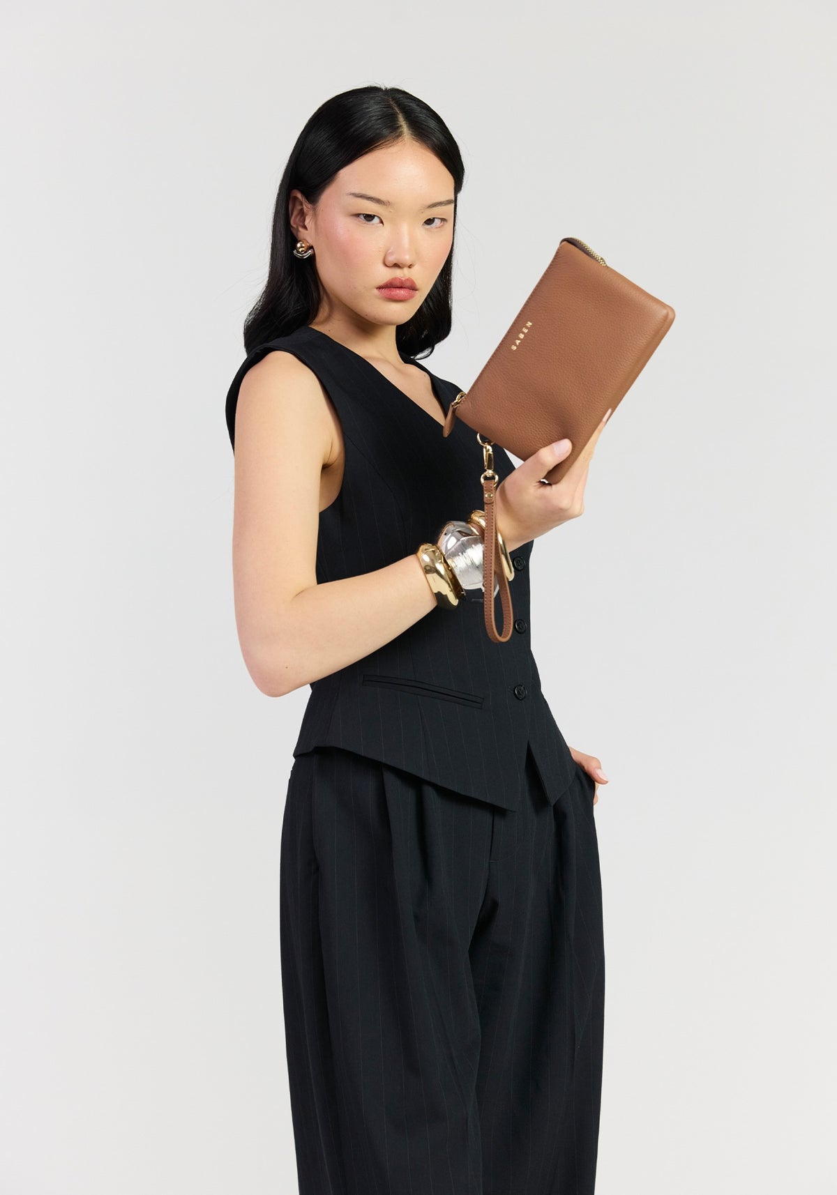 Saben Tilly crossbody tan held as a clutch