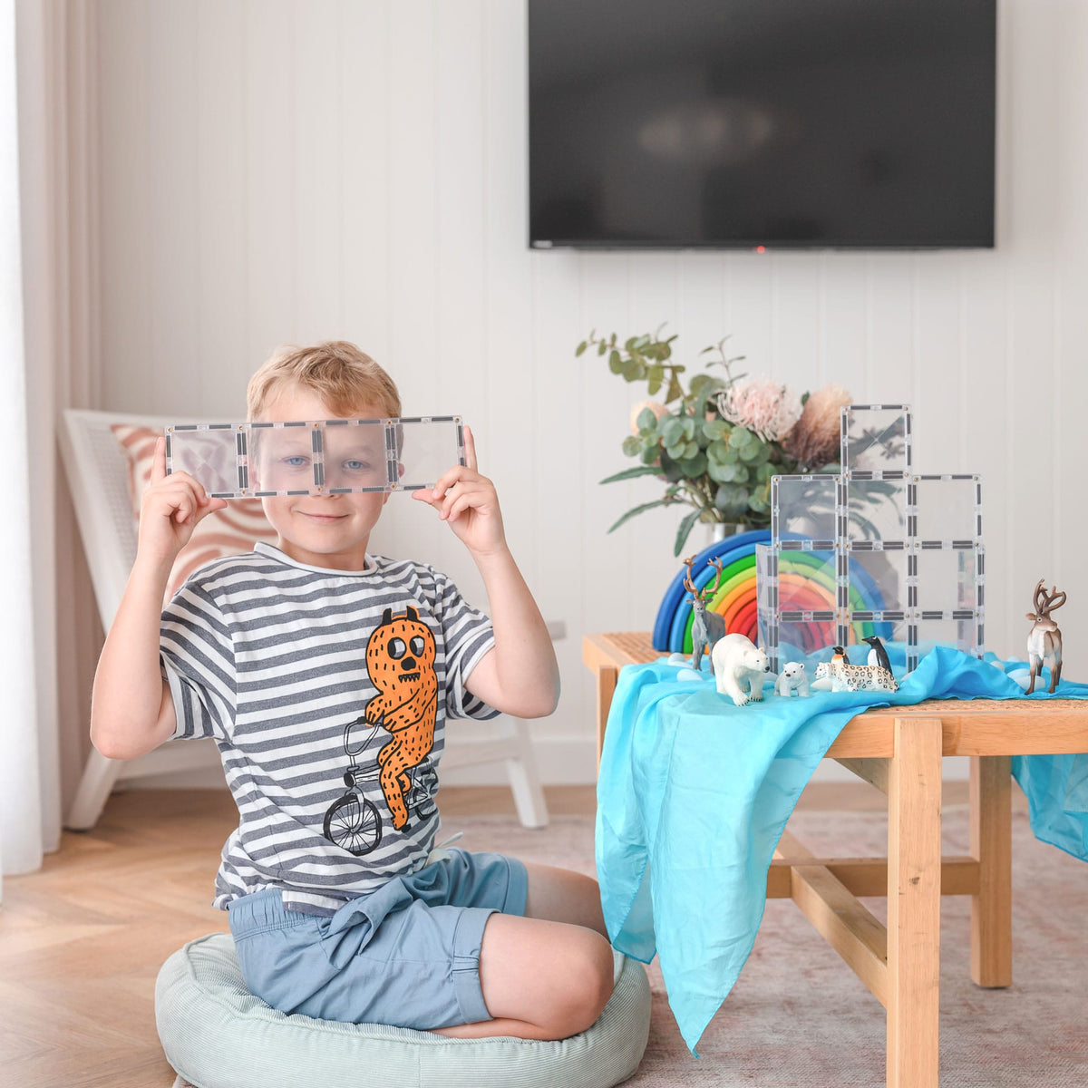 Child looking through a clear Connetix rectangle build