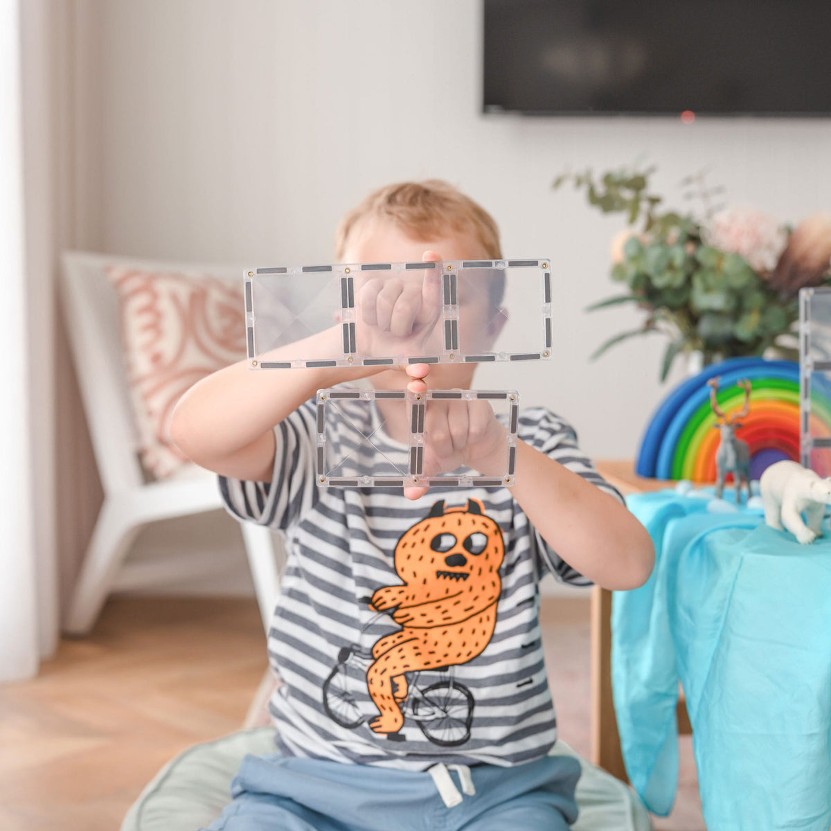 Child holding up clear Connetix rectangles