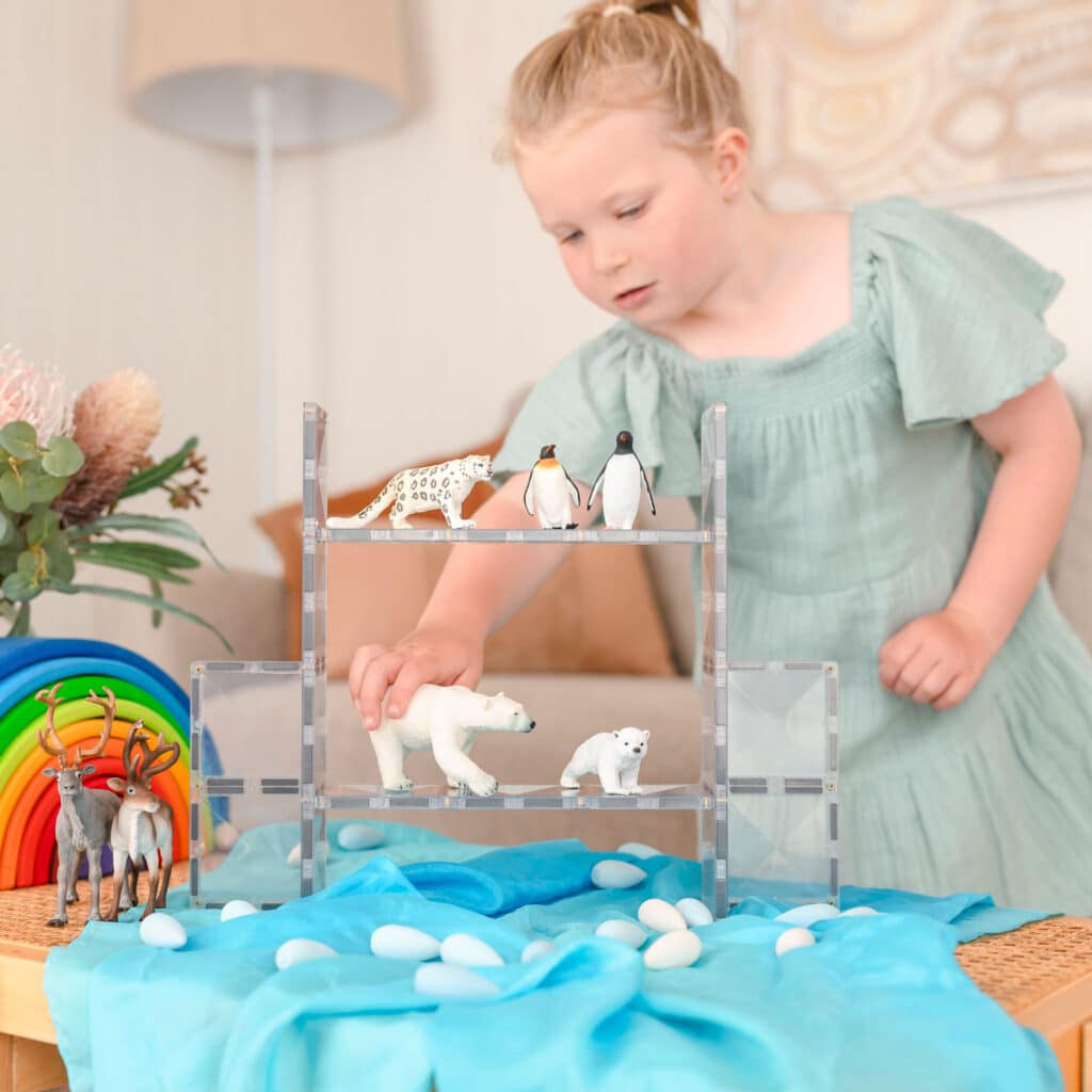 Child playing with a clear Connetix rectangle small world build
