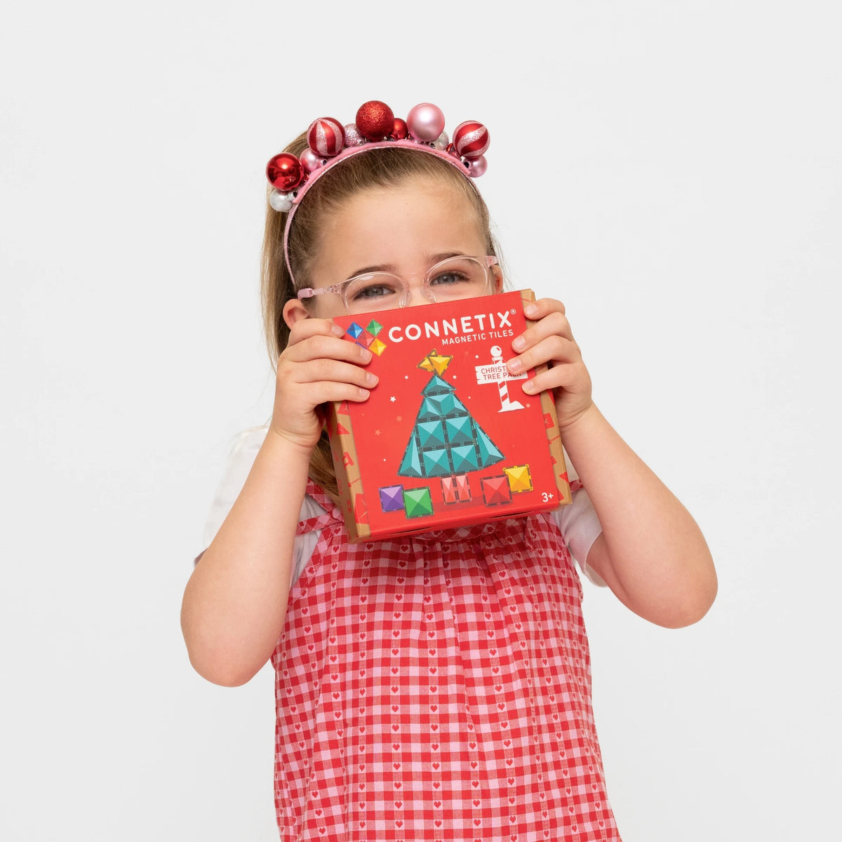 Child holding the Connetix Christmas Tree Pack box