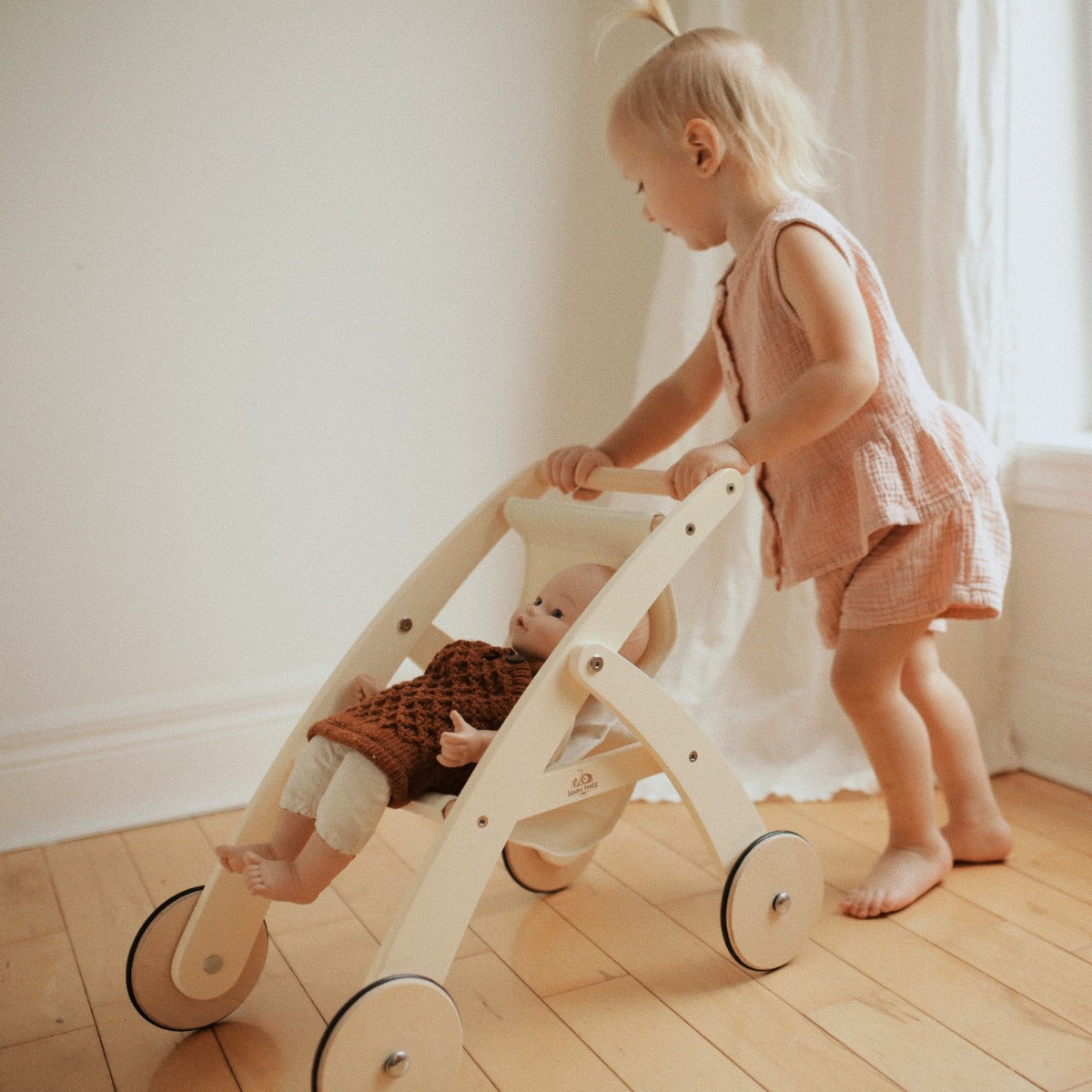 Toddler pushing the Kinderfeets Doll Stroller