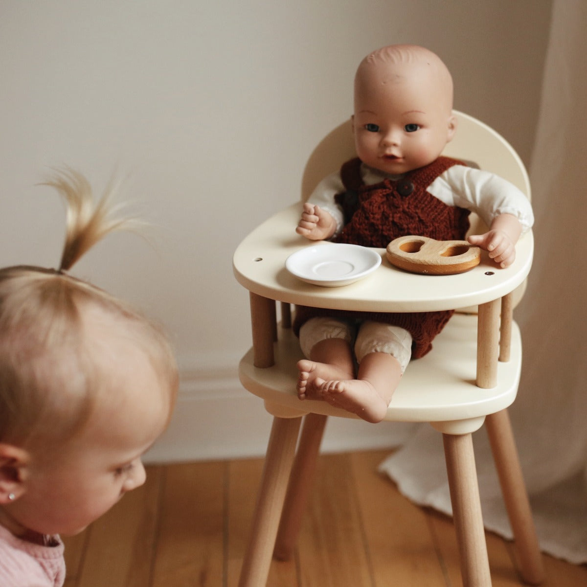 Child feeding a doll in the Kinderfeets Doll High Chair
