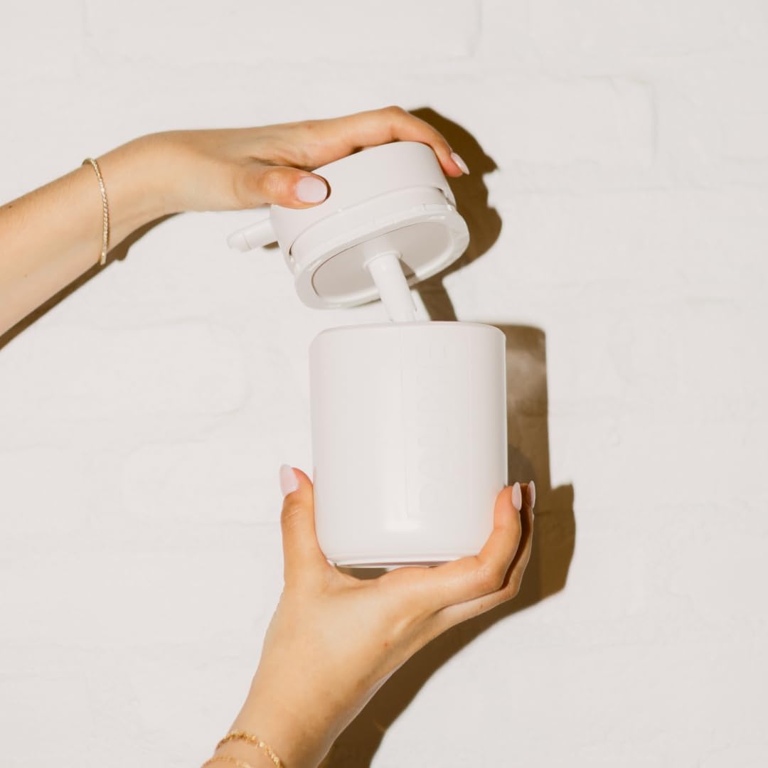 White ceramic jar with a lid being held by a hand on a light background
