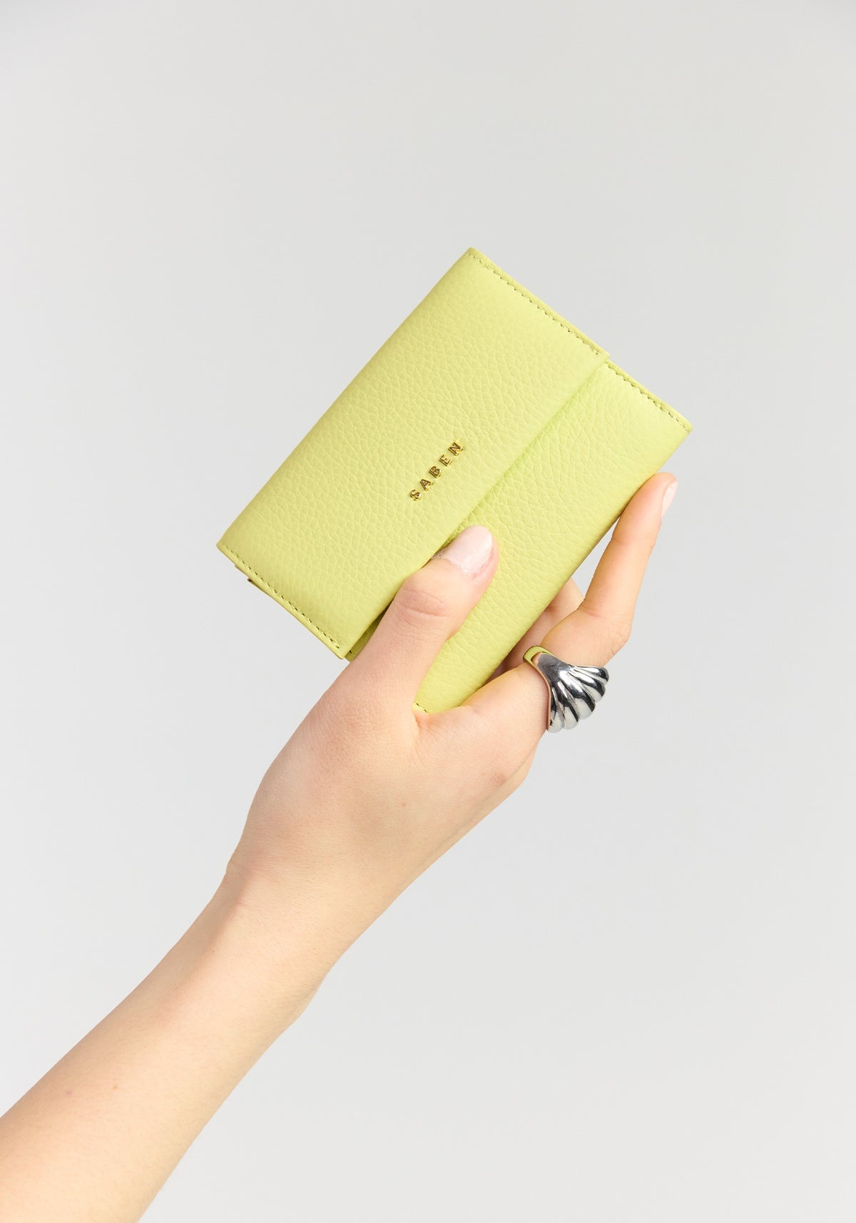 saben pico tri-fold wallet pistachio held in hand