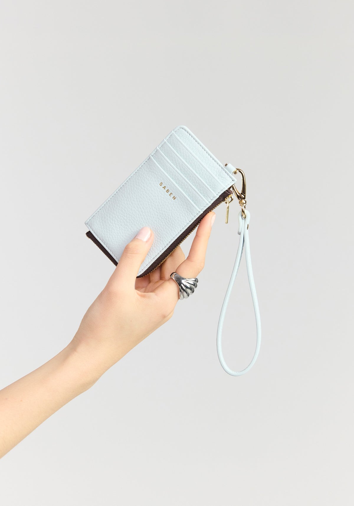 saben winona card holder wristlet elderberry held in hand
